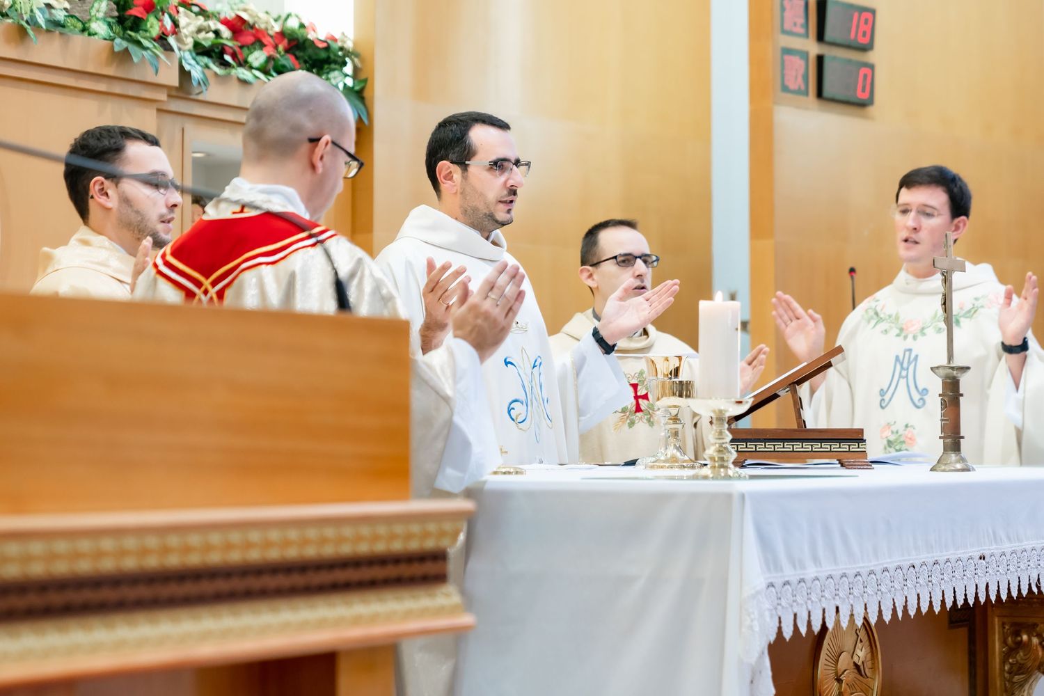 Clergy members performing religious ceremony at decorated altar.