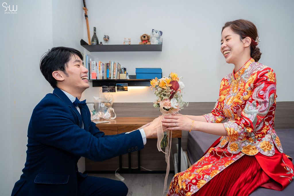 Romantic moment during Chinese wedding ceremony with couple exchanging flowers.