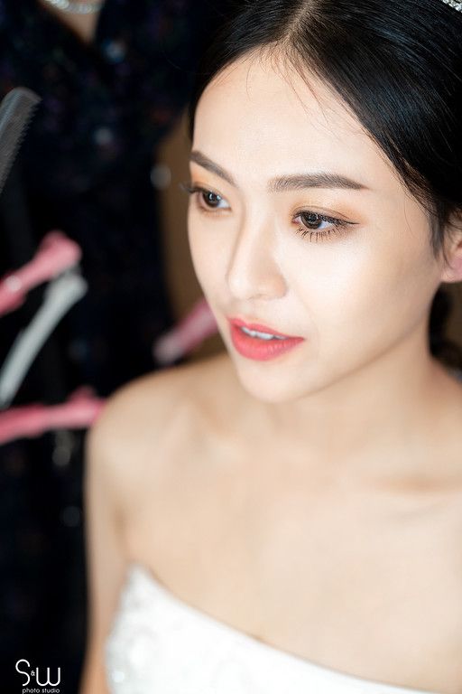 Close-up shot of bridal makeup with soft natural tones and pink lipstick.