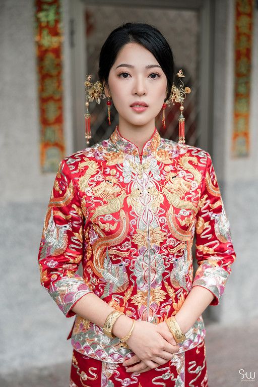 Traditional Chinese bridal portrait featuring ornate red and gold qipao dress with matching accessories.