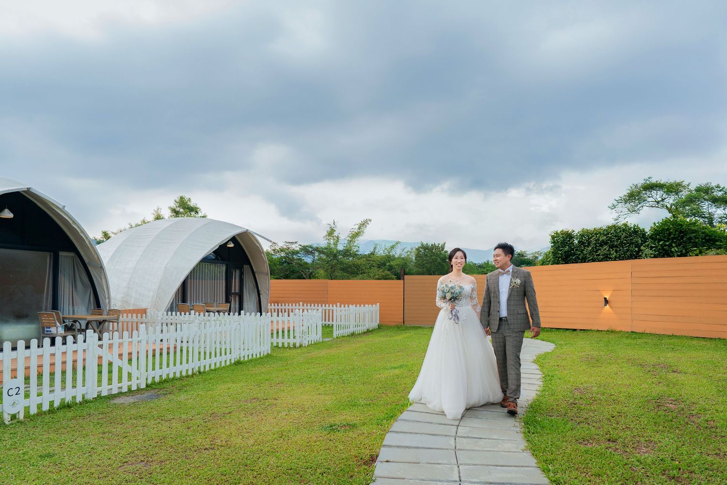 Five sequential wedding photos capturing moments of a couple in celebration at an outdoor venue with cloudy skies.