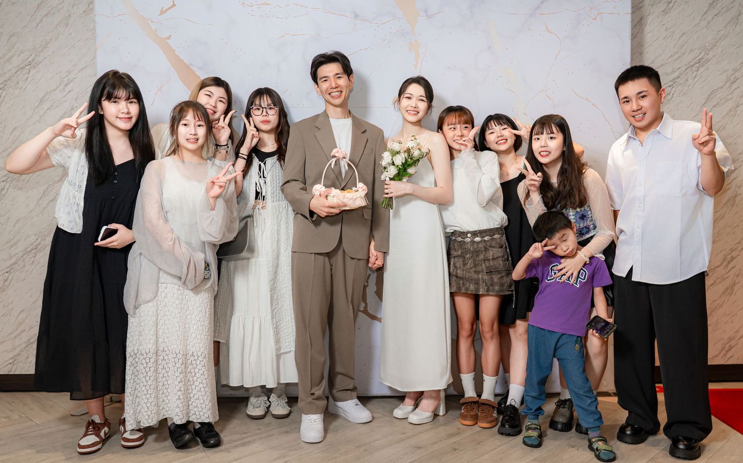 A collection of wedding party group photos showing celebratory poses against a light-colored wall.