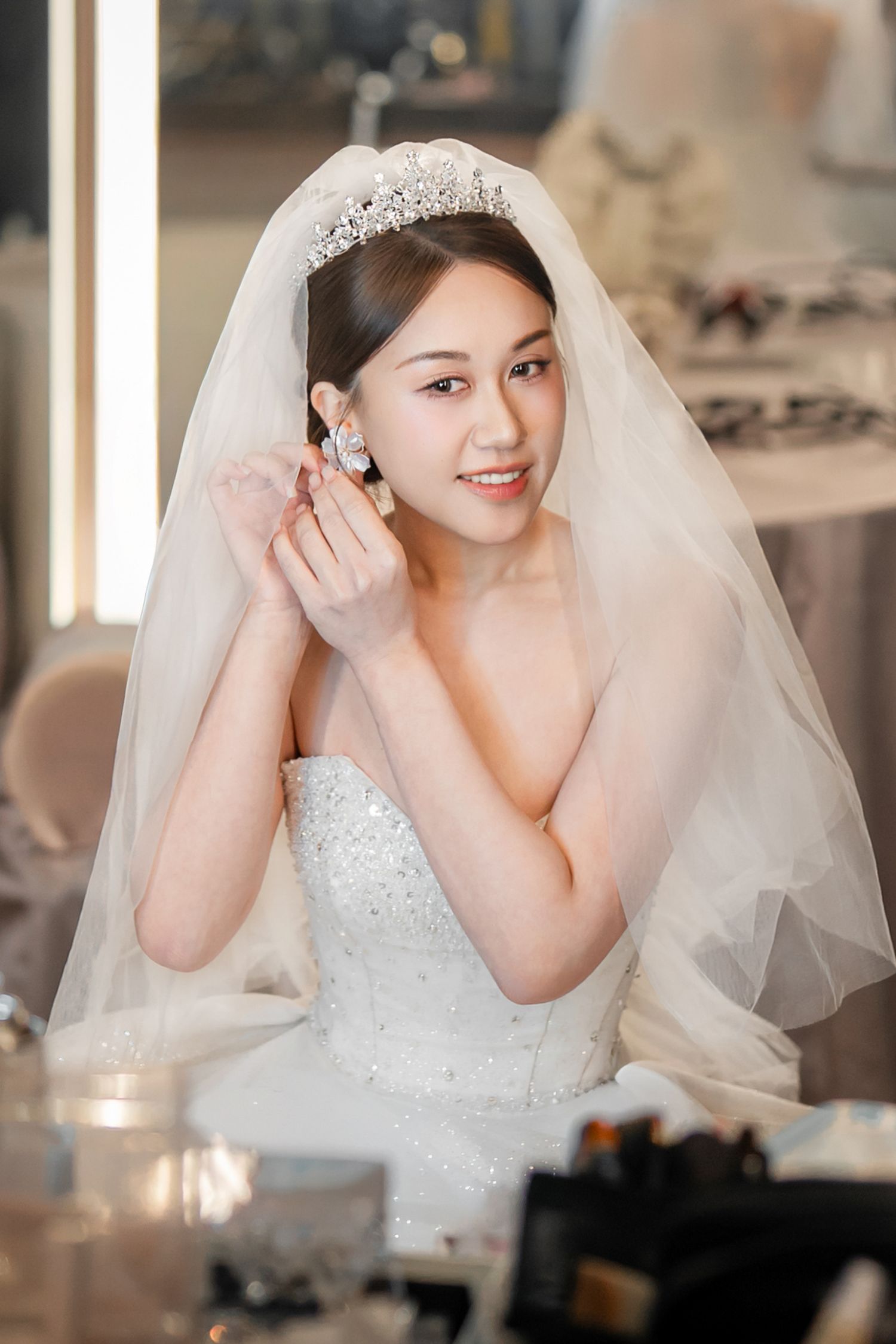 A bride in a white lace wedding dress and veil poses playfully in a series of candid getting-ready photos.