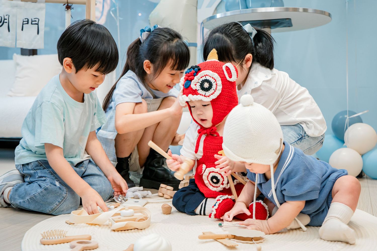 Children gathered on the floor working together with clay or dough materials during an arts and crafts activity.