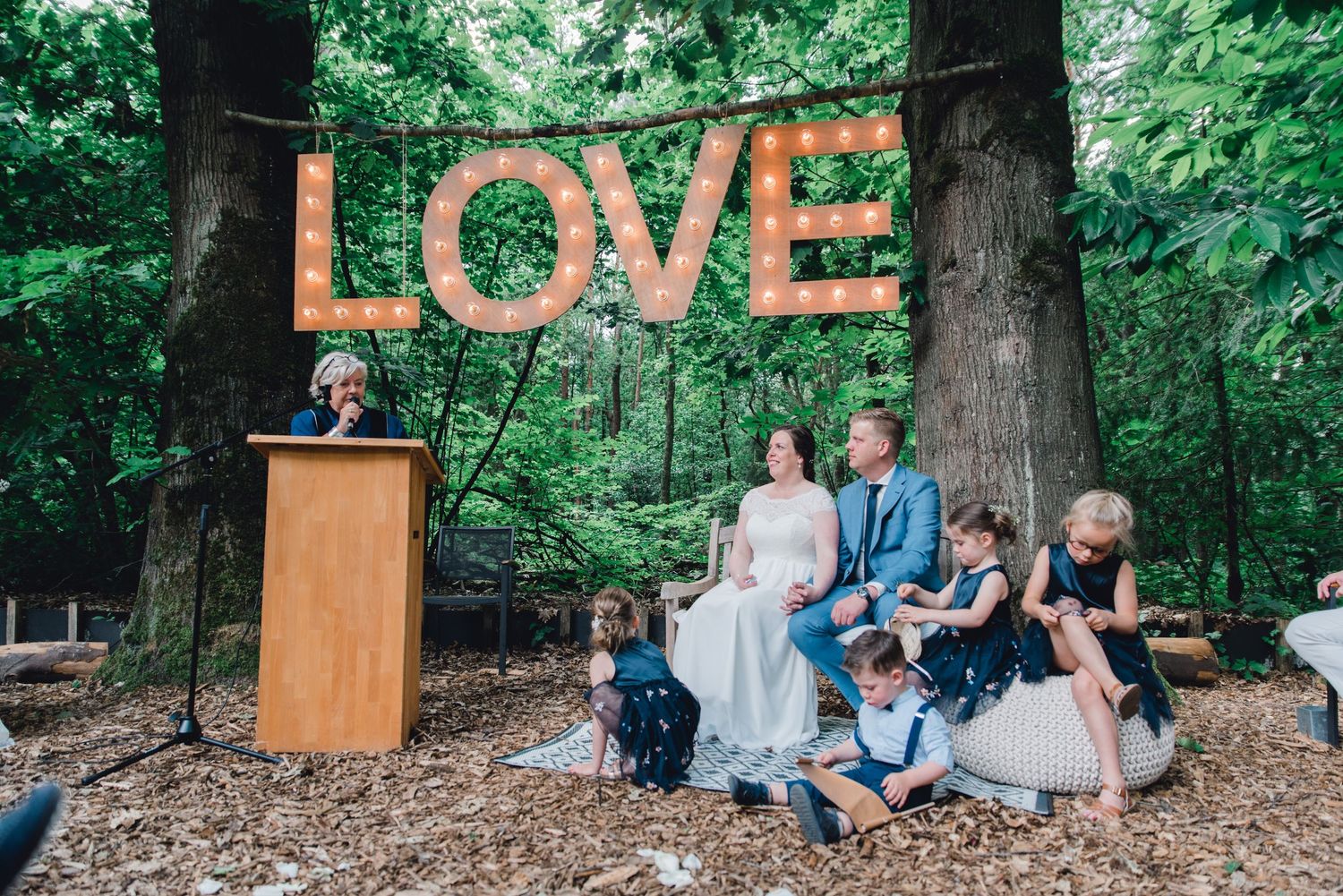Bruidspaar bij verlichte LOVE letters tijdens avond van hun bruiloft in Brabant, romantische trouwfotografie bij MR van Eijck