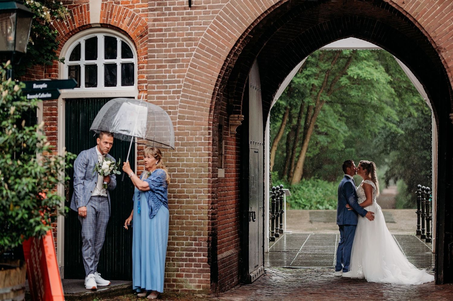 Bruidspaar gefotografeerd onder bakstenen bogen in verschillende romantische poses bij een trouwlocatie in Den Bosch.