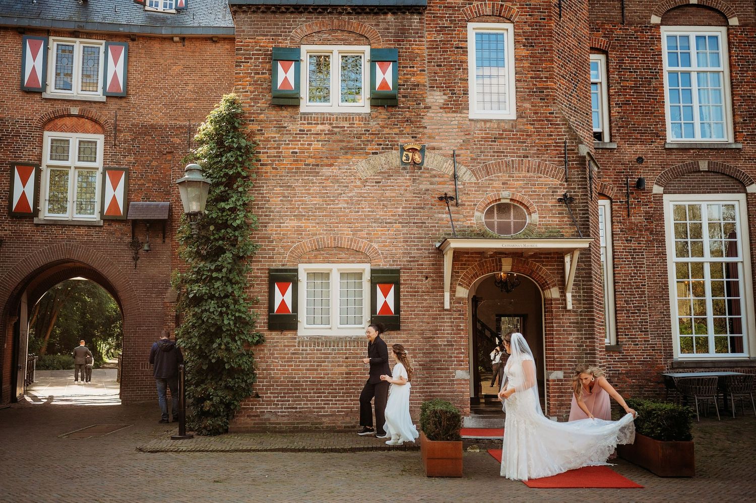 Elegante bakstenen gevel met witte ramen en klimplanten, klassieke trouwlocatie Brabant.