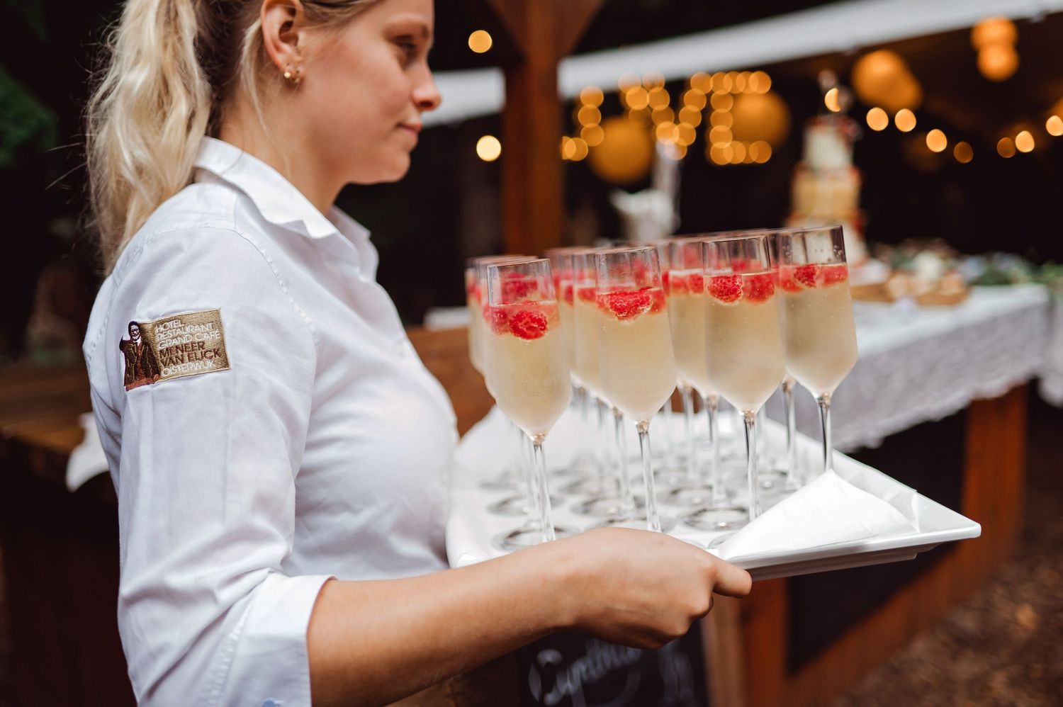 Bediening met champagneglazen tijdens bruiloft in Brabant, detail van trouwdag reportage