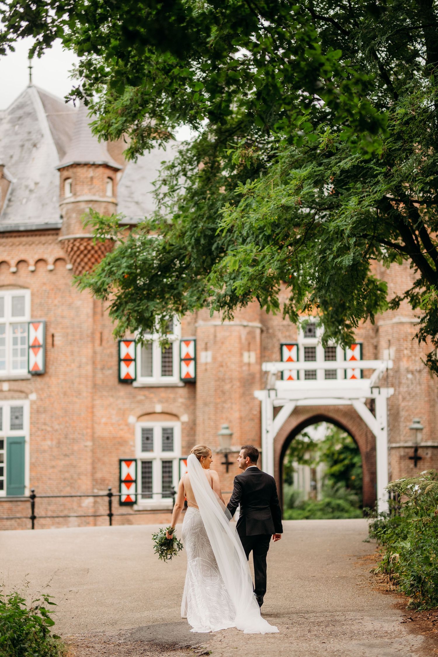 Elegante trouwportret bij hoge ramen met vintage behang en houten vloeren, bruidsfotografie Brabantbruidsfotografie Brabant
