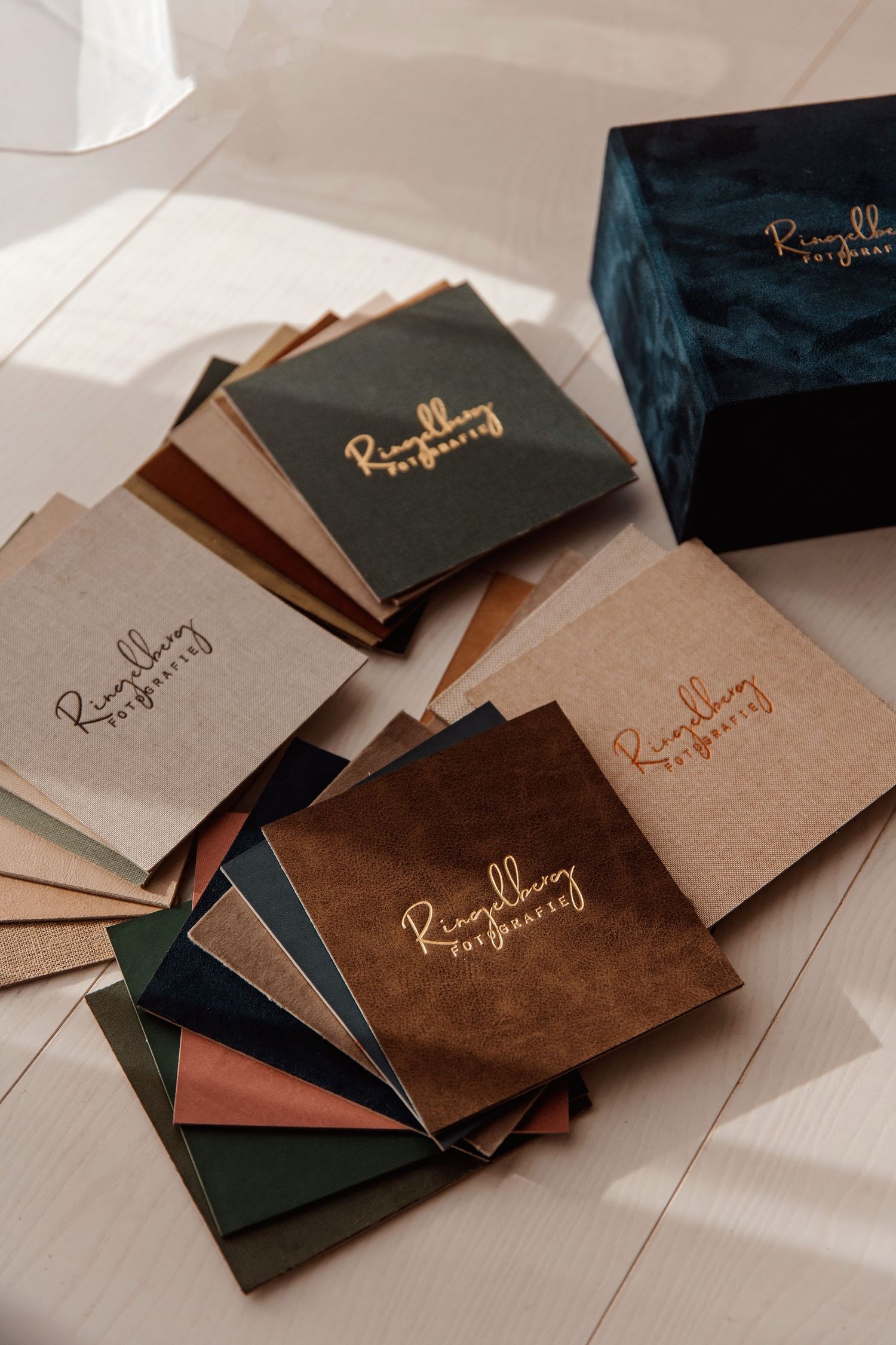 Scattered wedding stationery and envelopes with gold lettering in natural lighting.