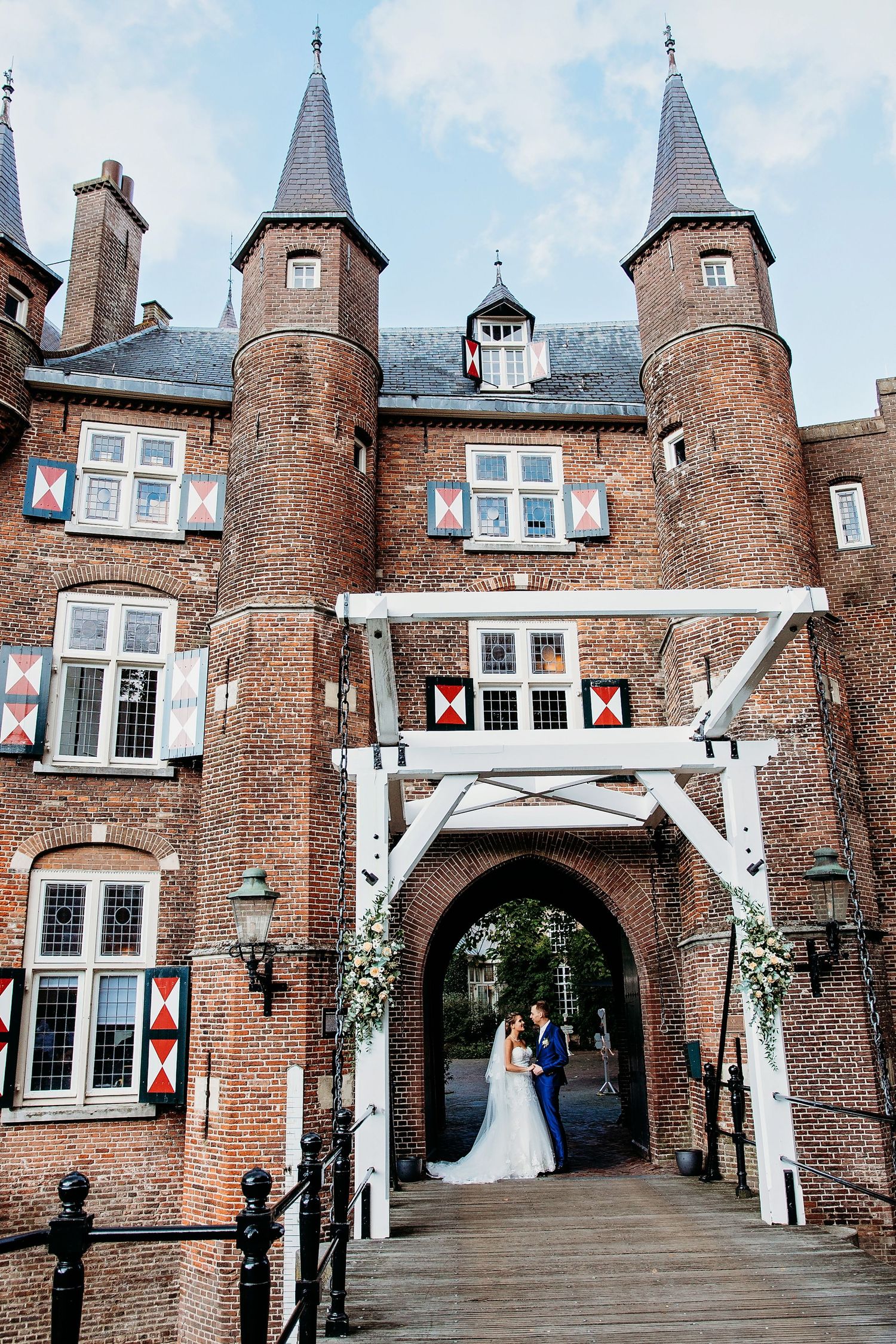 Historisch kasteel met torens en witte boog bij entree, bruidsfotografie Kasteel Maurick Vught, Brabant.