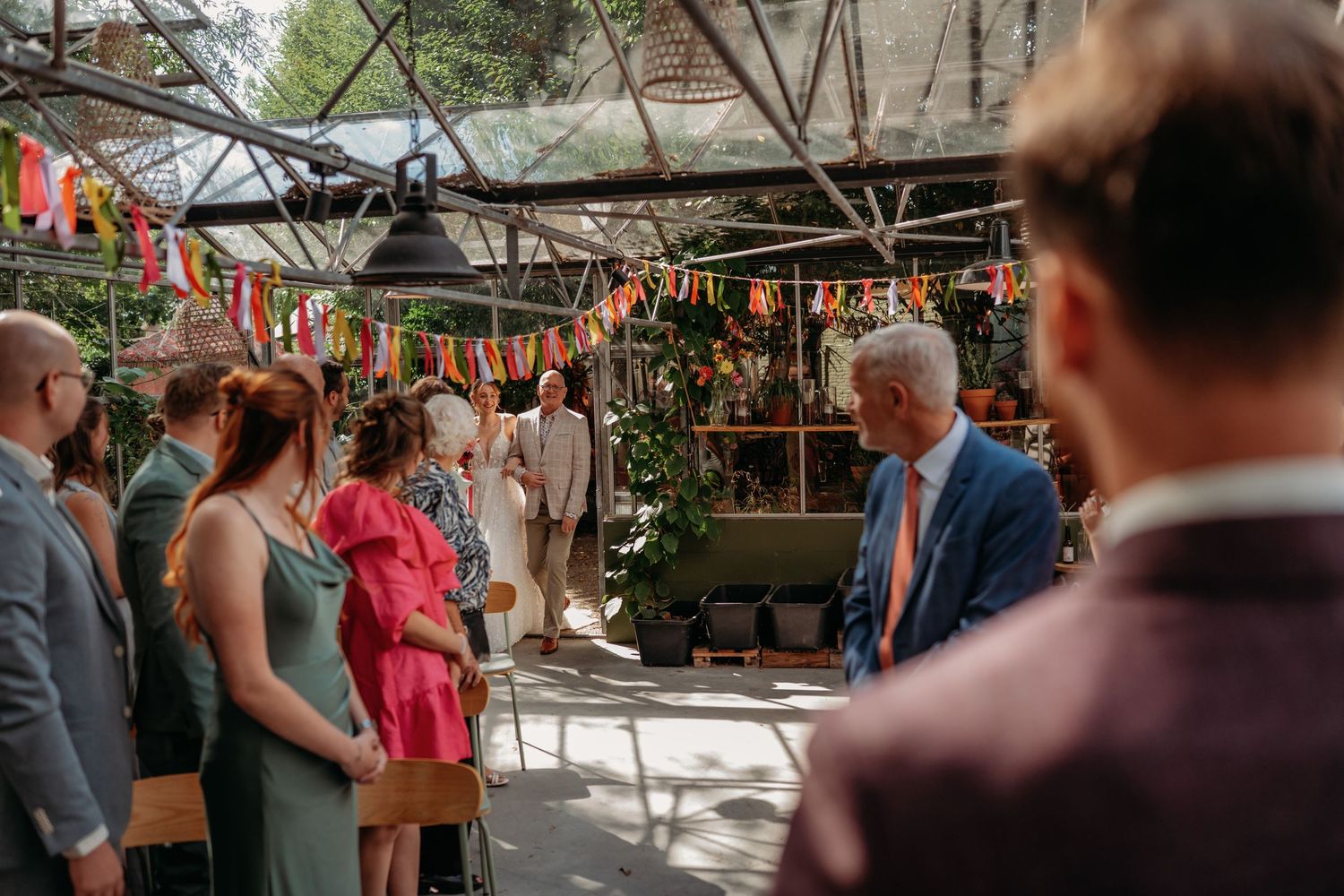 Trouwlocatie kas met vlaggetjes en decoratie tijdens ceremonie in de buitenlucht in Brabant