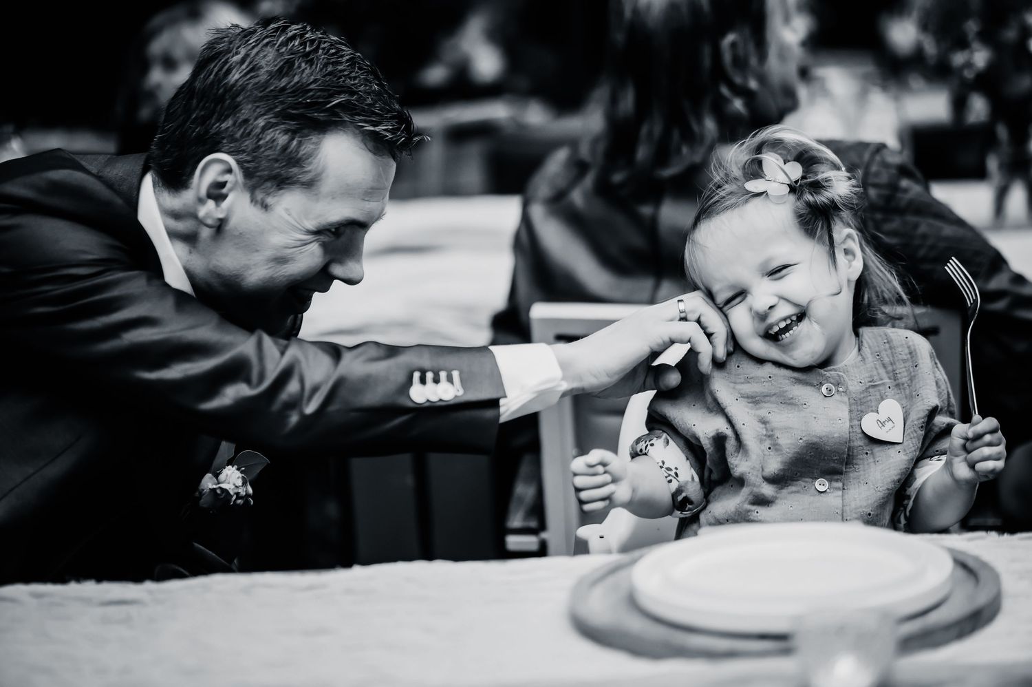 Zwart-wit foto vastlegt spontane lach tijdens bruiloftsreceptie, bruidsfotografie Brabant