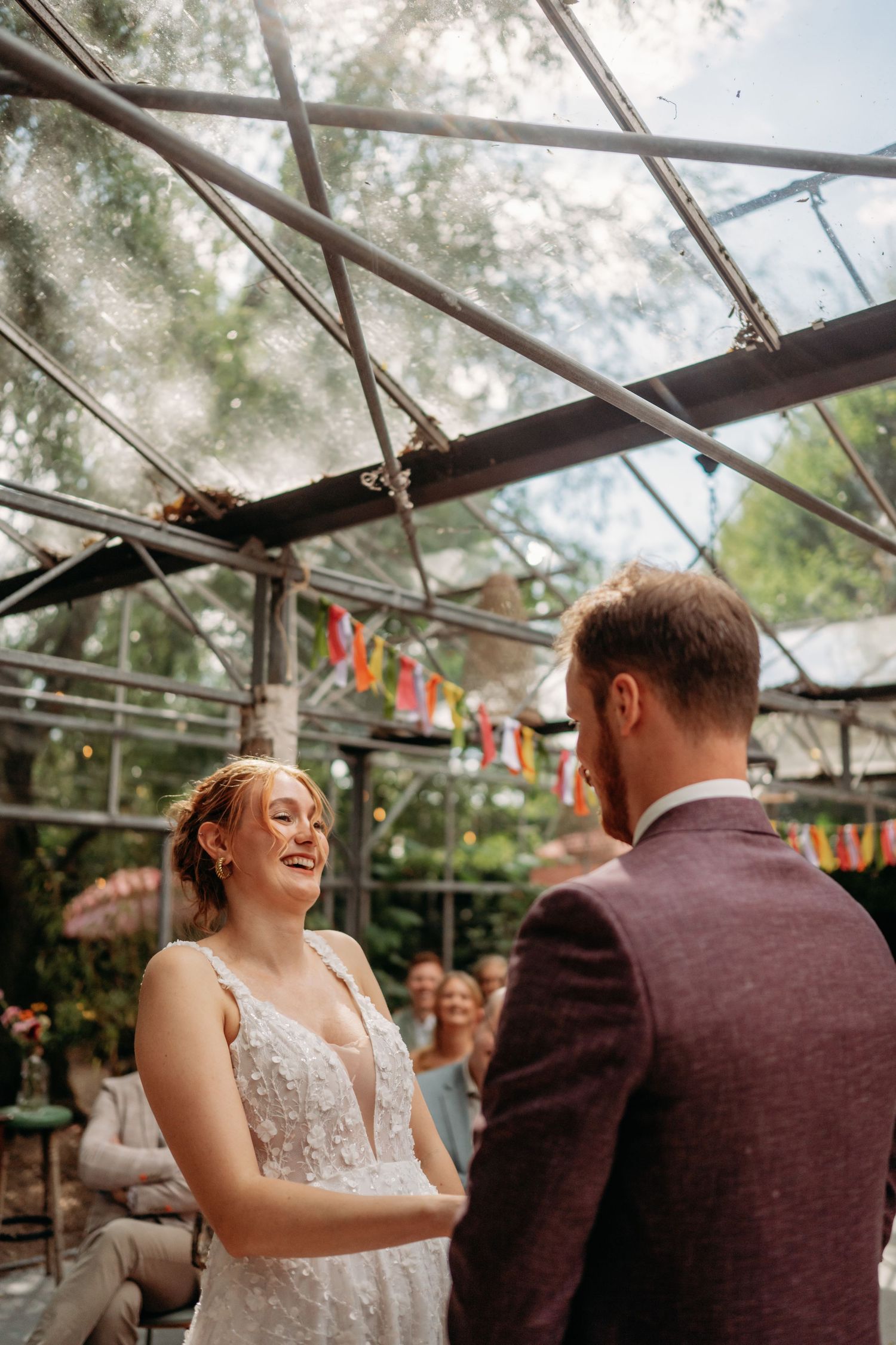 Bruidspaar zittend samen tijdens ceremonie in kas op hun trouwdag in Brabant, pure en spontane reportage