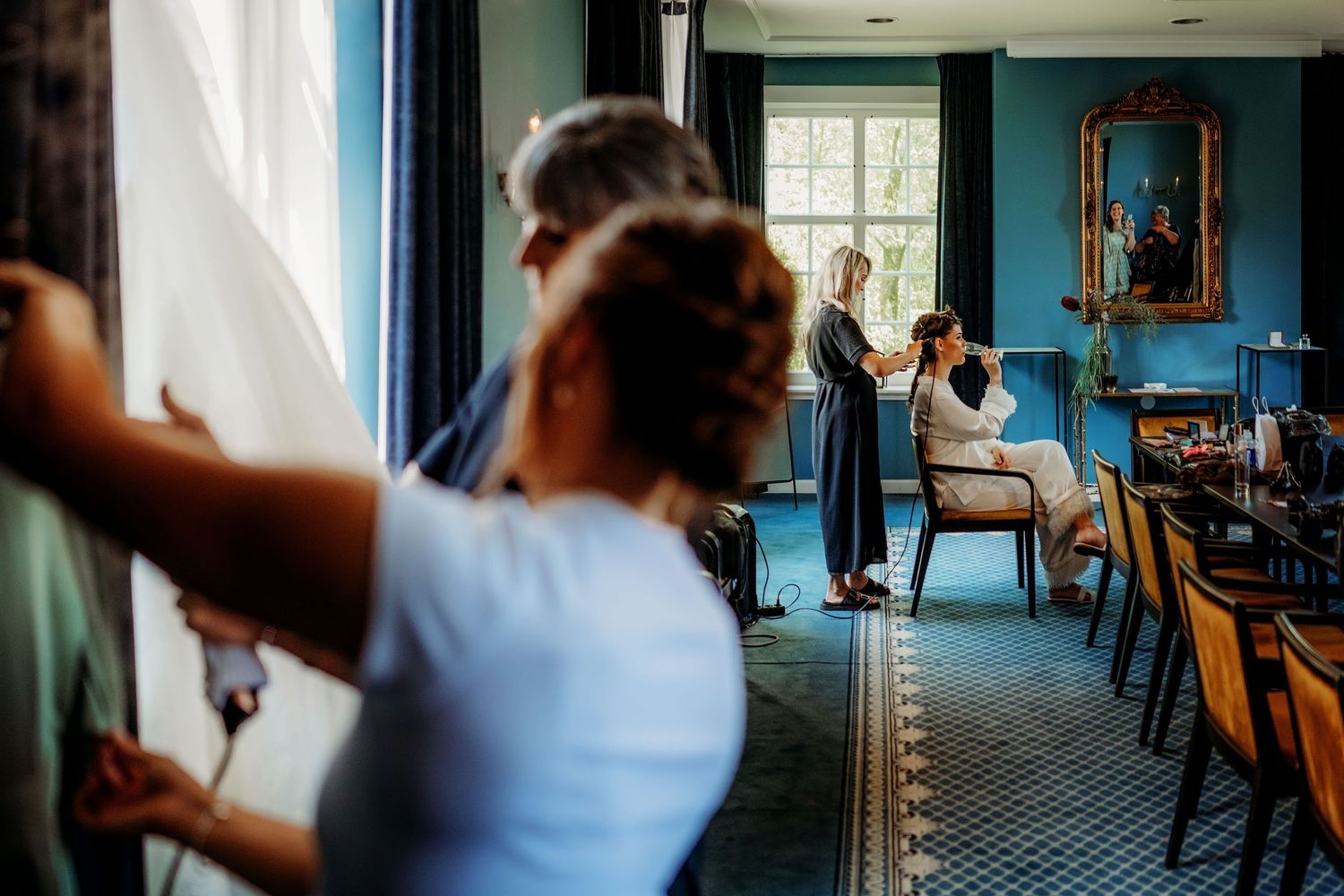 Mensen verzamelen in elegante blauwe zaal met vintage meubels en hoge ramen, portretfotografie Vught, Brabant op Kasteel Maurick