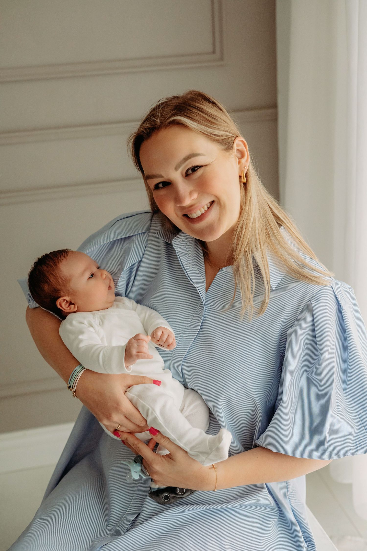 Teder moment tijdens newborn fotoshoot met lichtblauwe en witte kleding, newbornfotografie Brabant