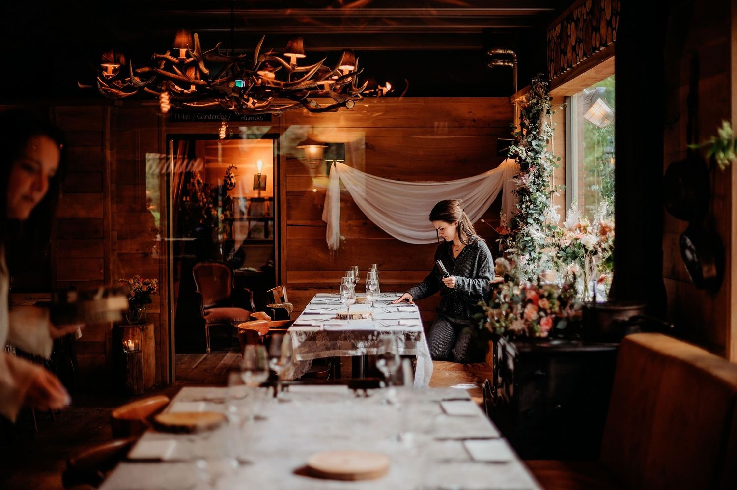 Elegante bruiloftsreceptietafels met bloemstukken in rustieke houten schuur, bruidsfotografie Brabant