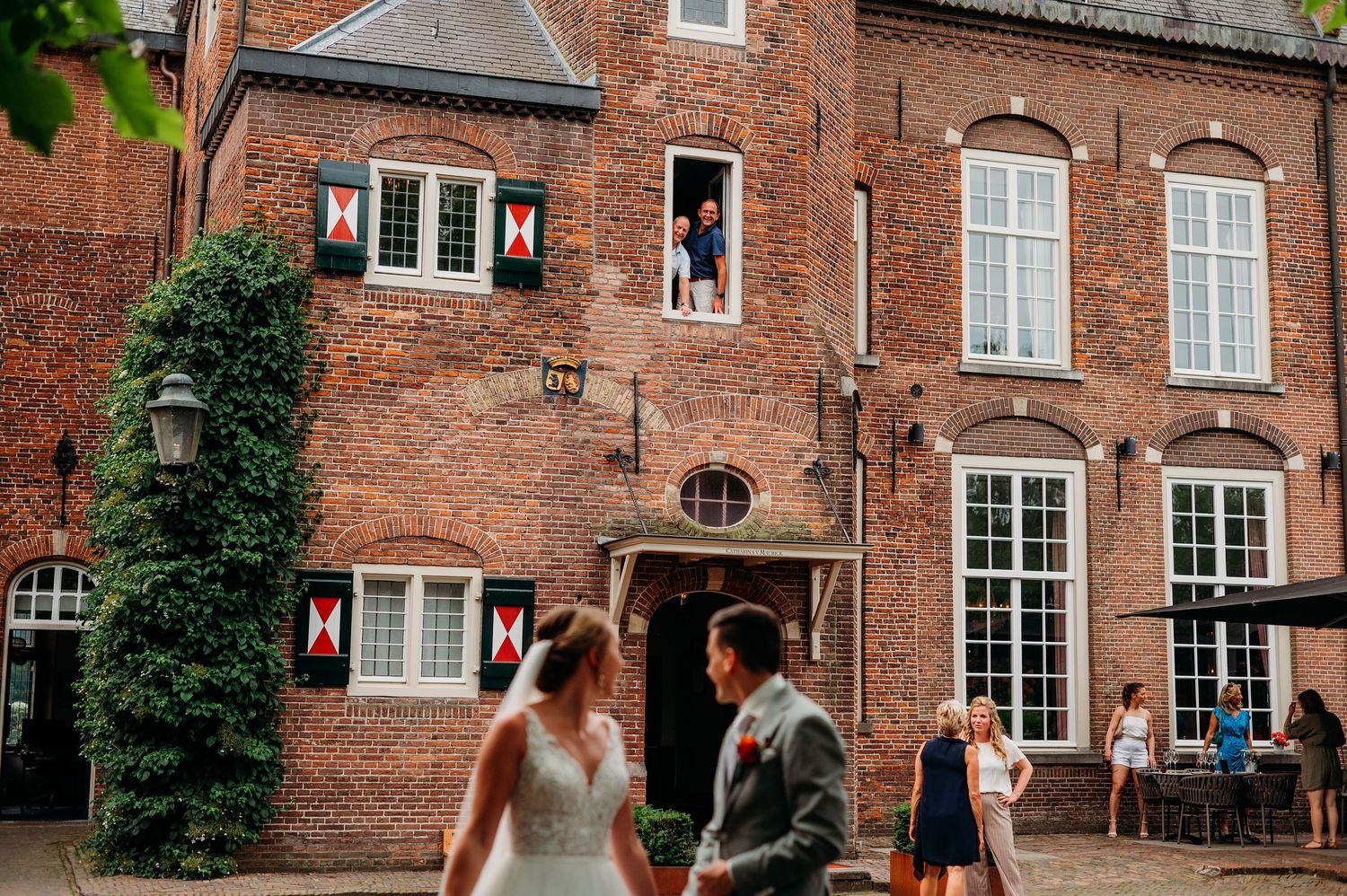 Bruid staat tussen bloeiende hortensia’s in de tuin van Kasteel Maurick in Vught, zachte en vrouwelijke bruidsfotografie