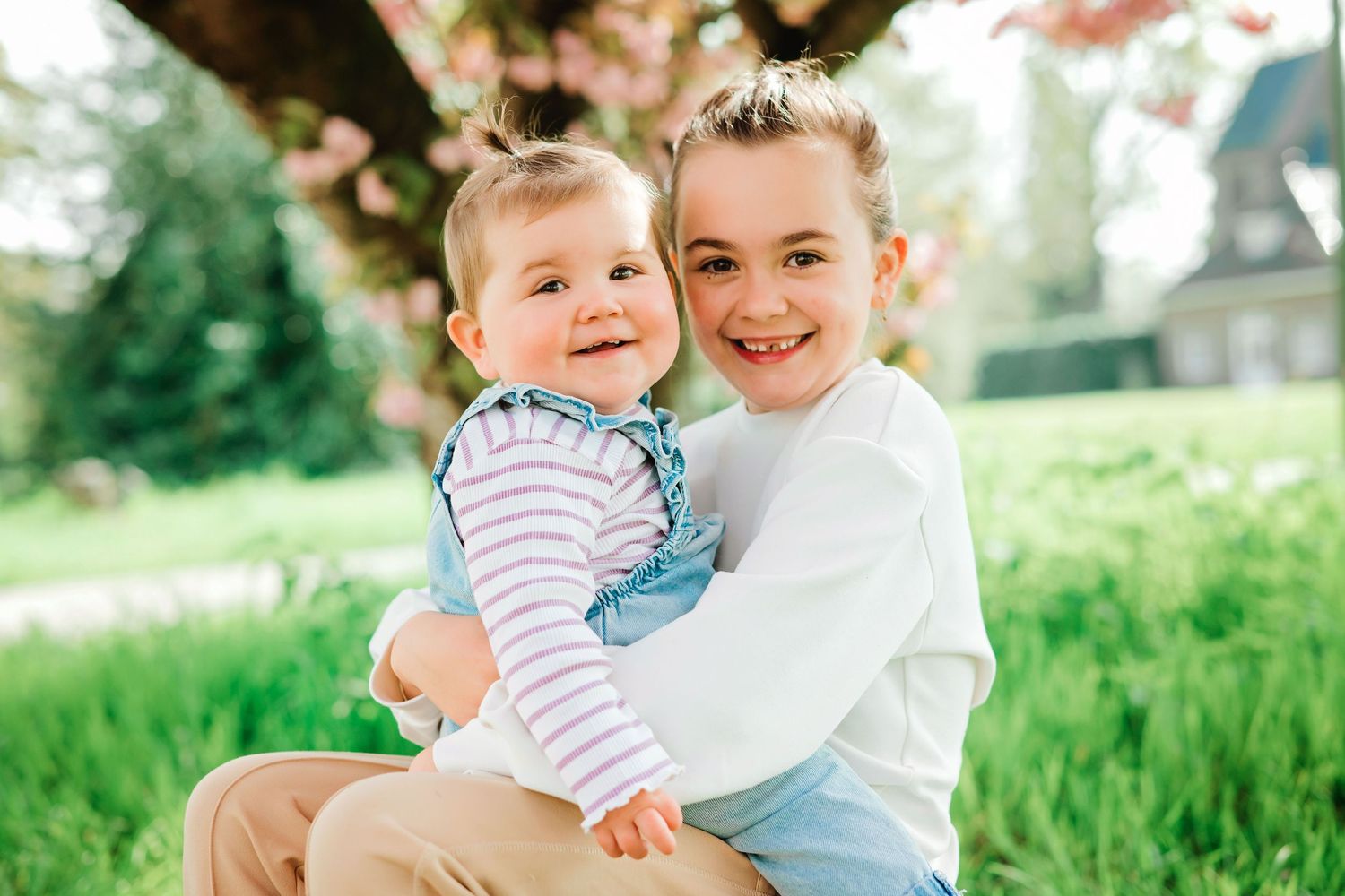 Gezinsshoot met kinderen buiten in Vught, spontane familiefoto in groene omgeving met bloesem