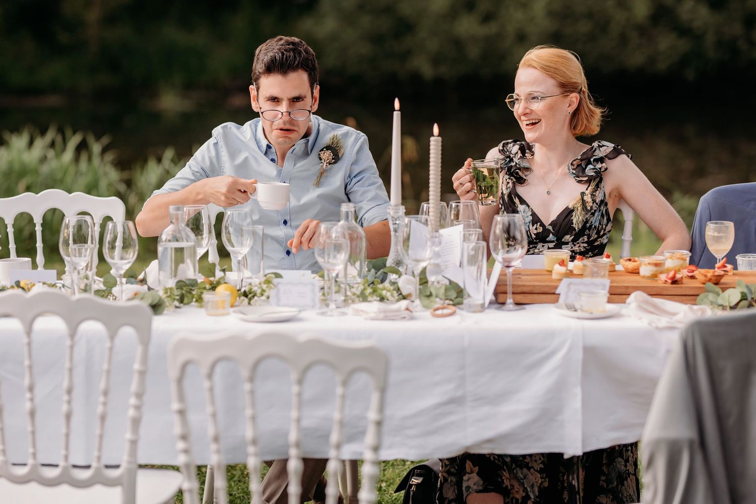 Buitenevenement met lange witte tafels en elegante opstelling, trouwfotograaf Brabant.