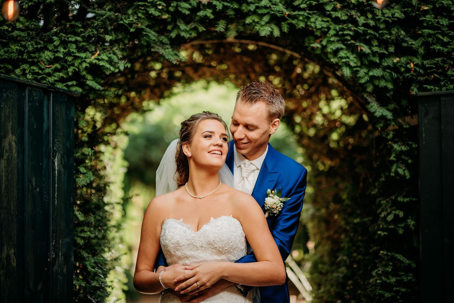 Bruidspaar poseert onder mooie bakstenen boog, bruidsfotografie Kasteel Maurick Vught, Brabant.