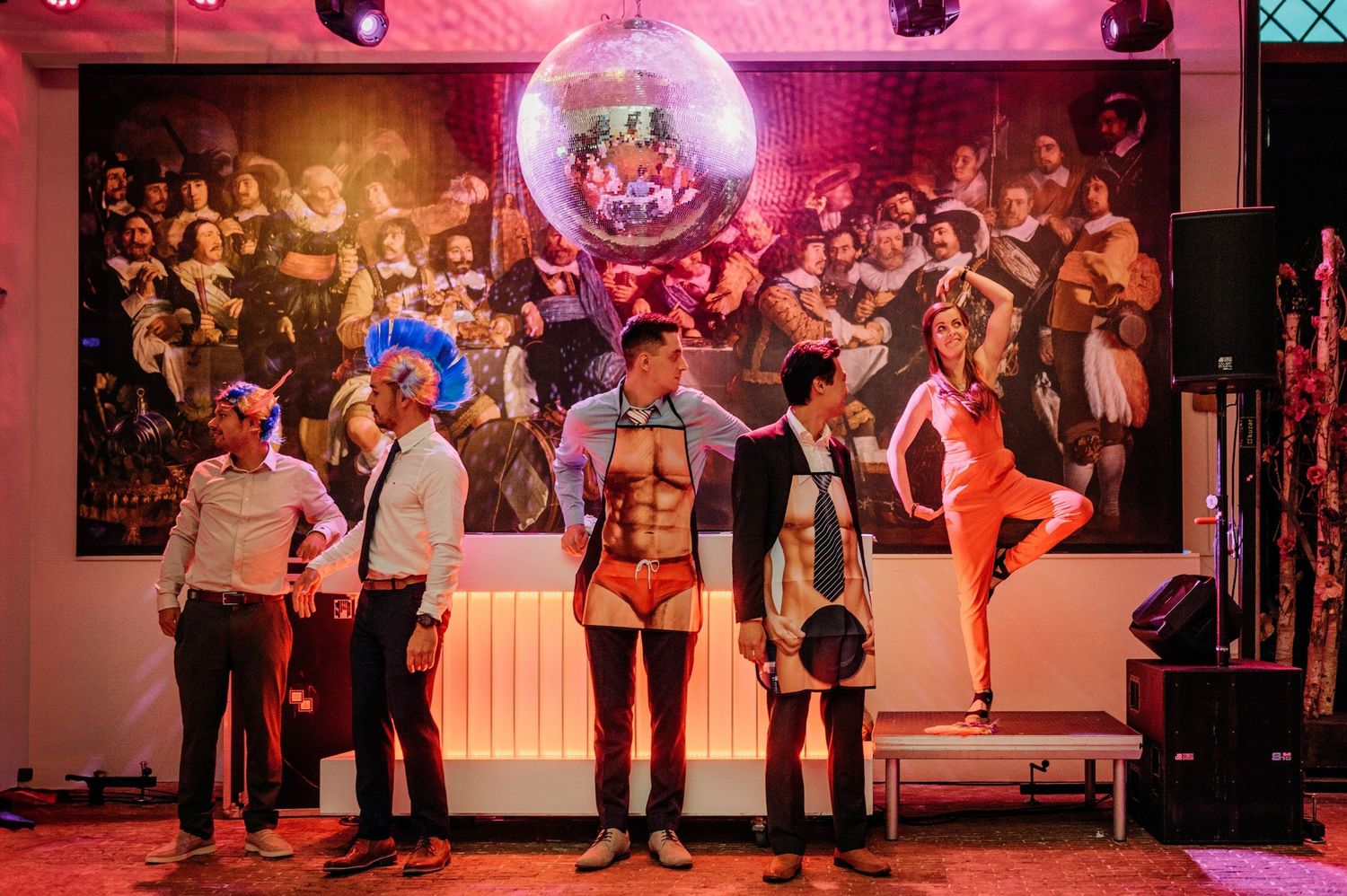 Bruiloftsfeest op dansvloer met discobal en rode verlichting, bruisfotografie Brabant