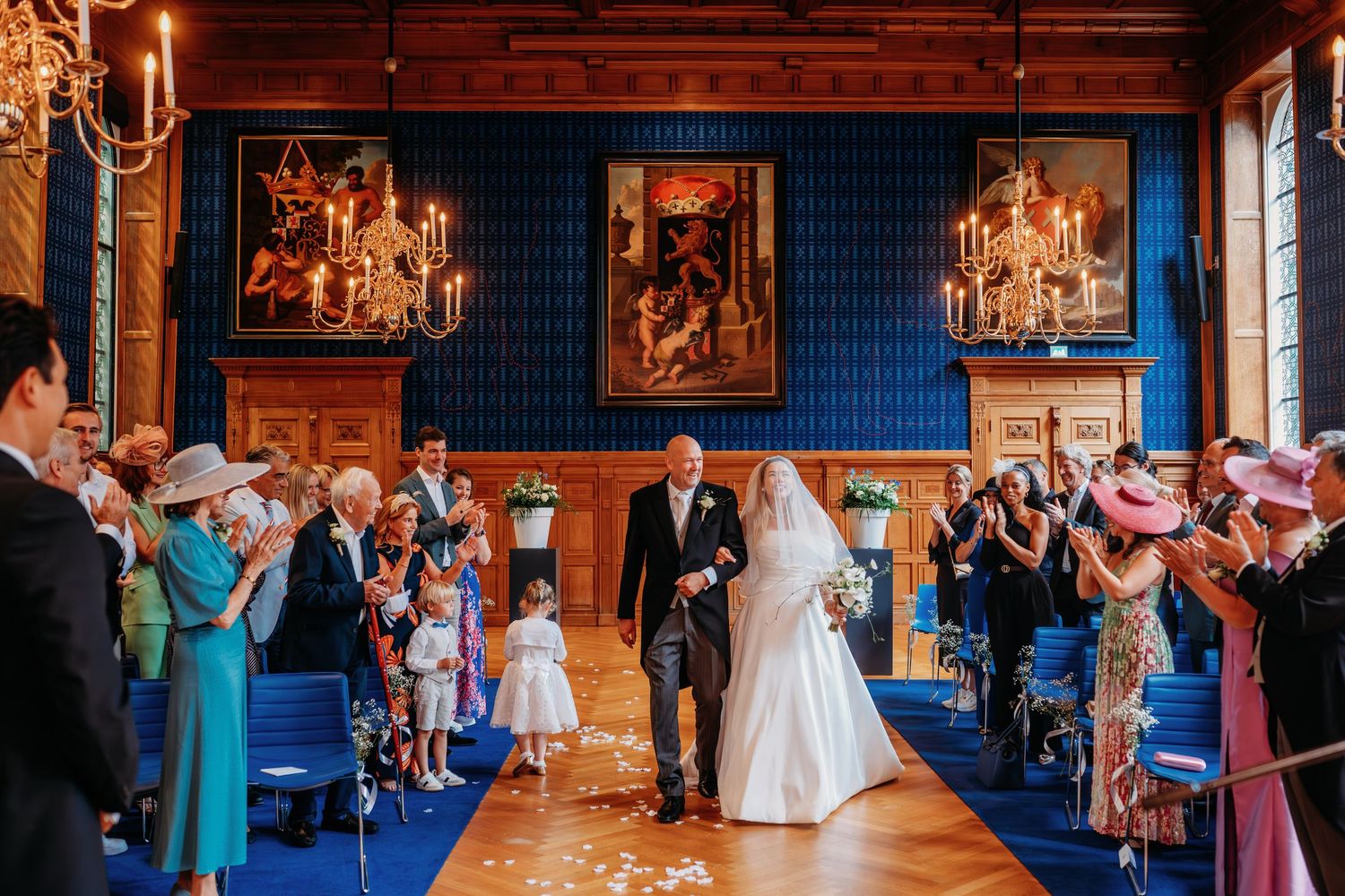 Wedding reception in rustic venue with blue walls and warm candlelight.