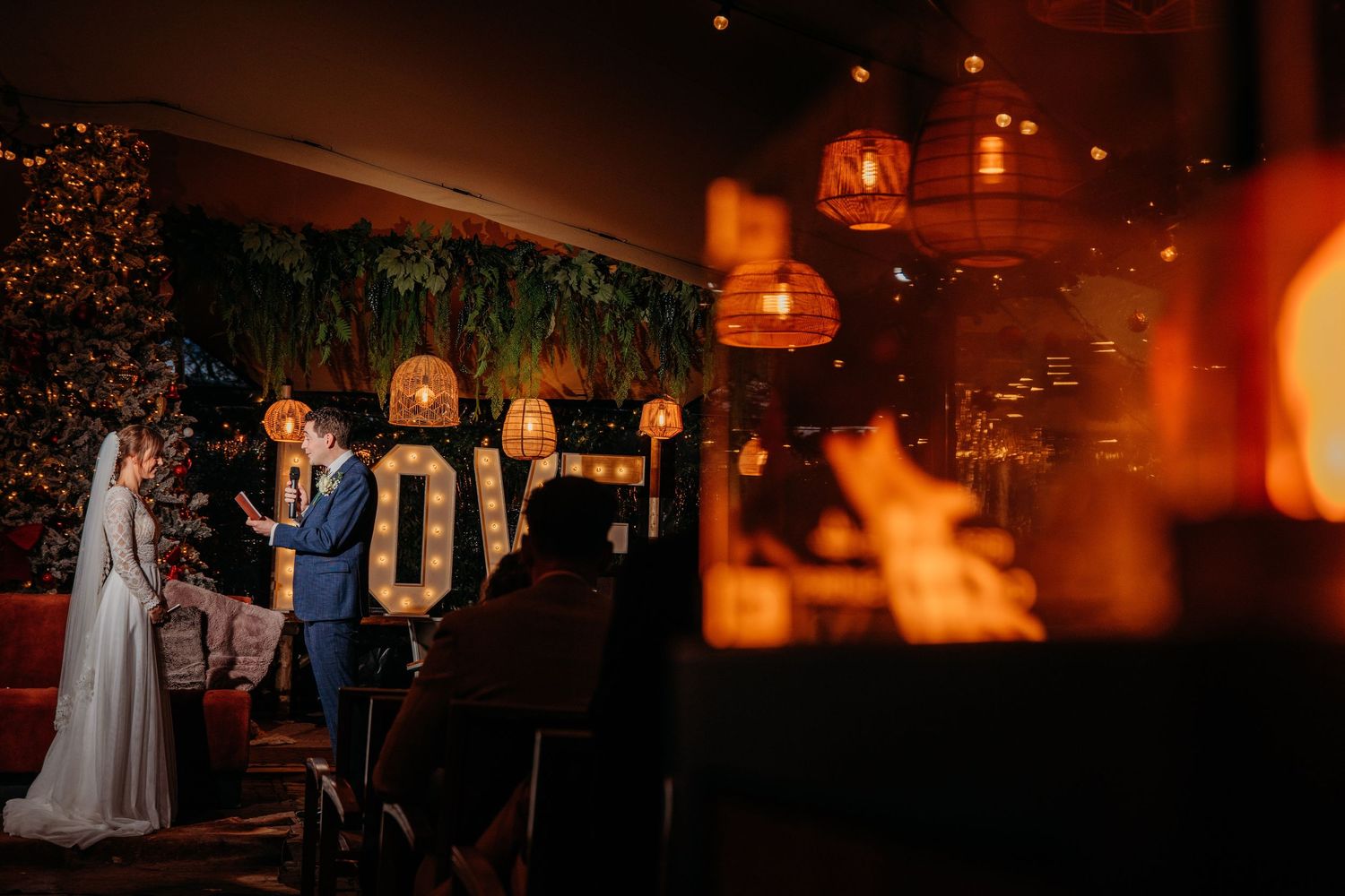 Sfeervolle trouwlocatie binnen met oranje licht en lampionnen, bruidsfotografie bij Boscafé Oisterwijk, regio Brabant.