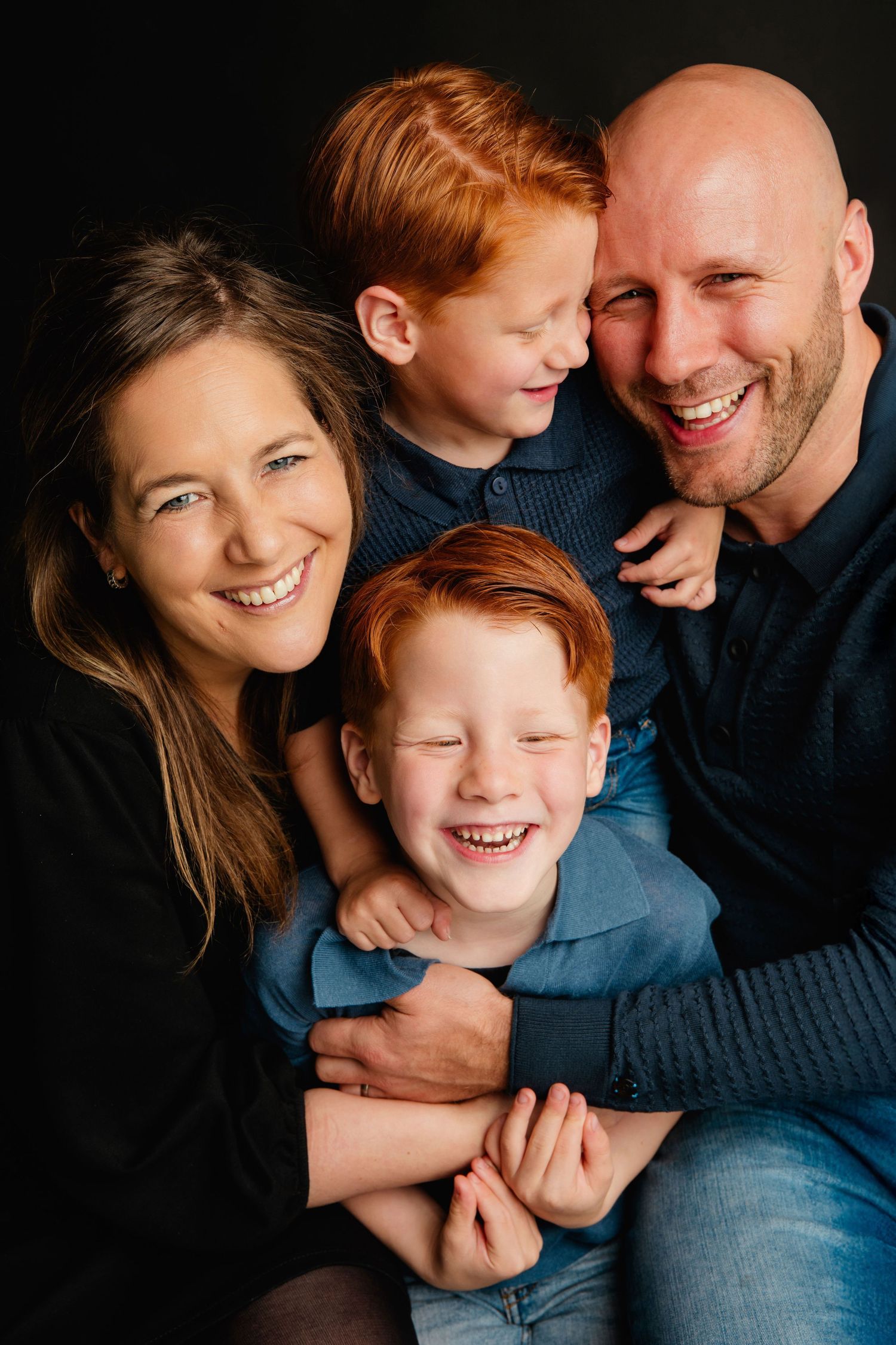 Gezinsshoot in studio in Vught met donkere achtergrond, warme en spontane familiefotografie
