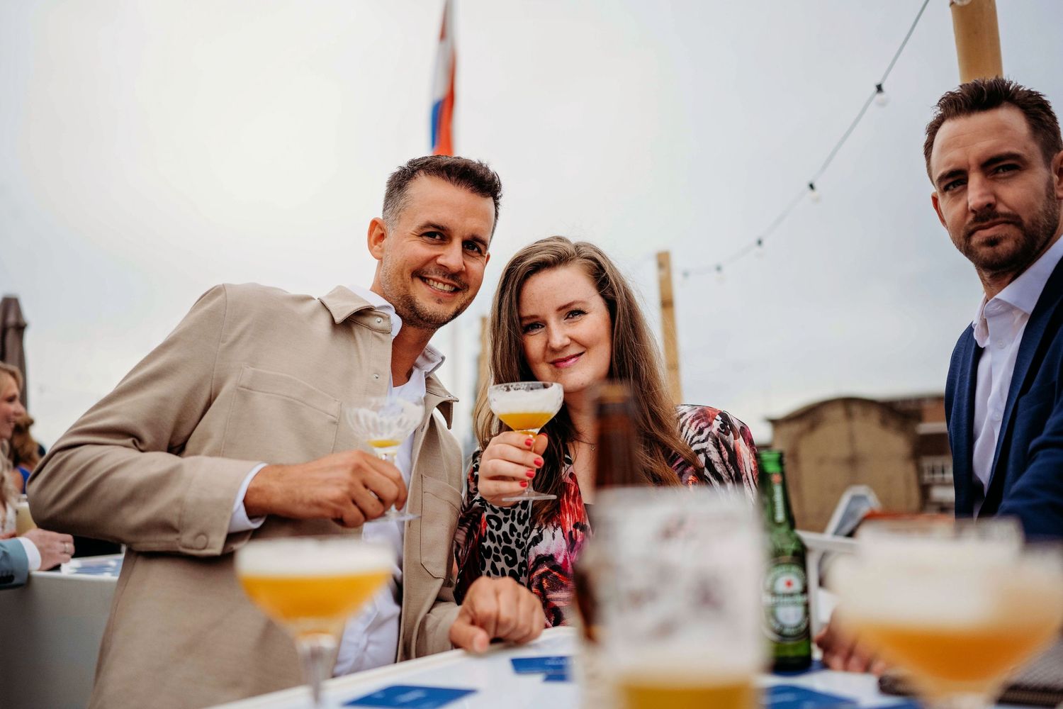 Bruiloftsgasten genieten van drankjes tijdens buitenreceptie, spontane bruidsfotografie in Den Bosch en omgeving Brabant.