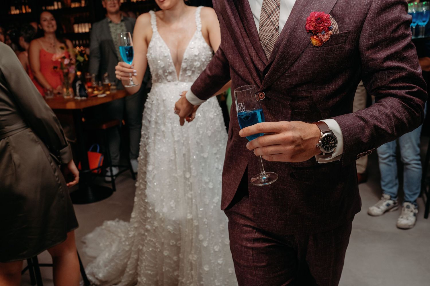 Detail van bruidspaar tijdens feest met cocktails en stijlvolle kleding, avondfotografie bruiloft Brabant