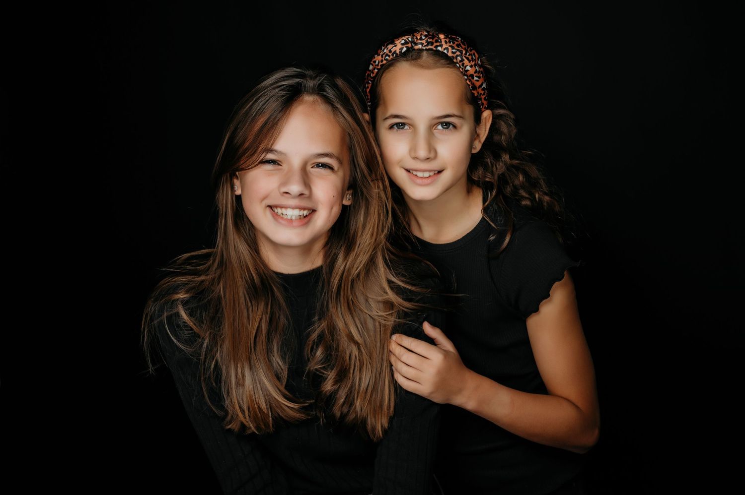 Portret van twee lachende personen tegen donkere achtergrond, portretfotografie Vught, Brabant.