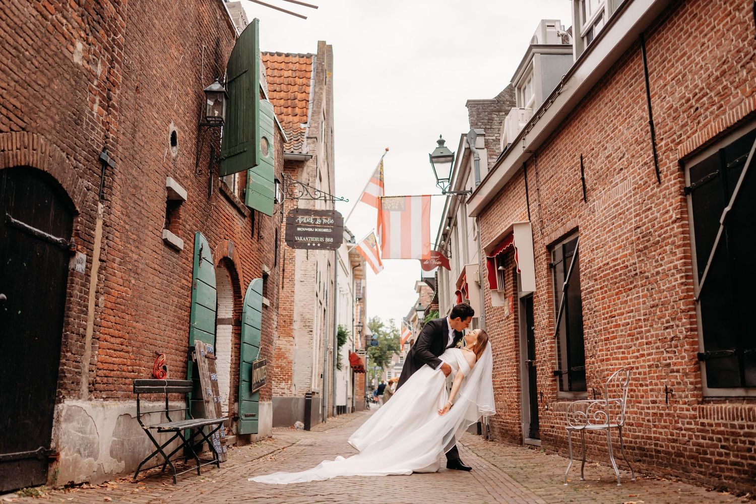 Panoramisch uitzicht op historische bakstenen steeg met geplaveide straat en oude gebouwen, bruidsfotografie Noordbrabants Museum Den Bosch,