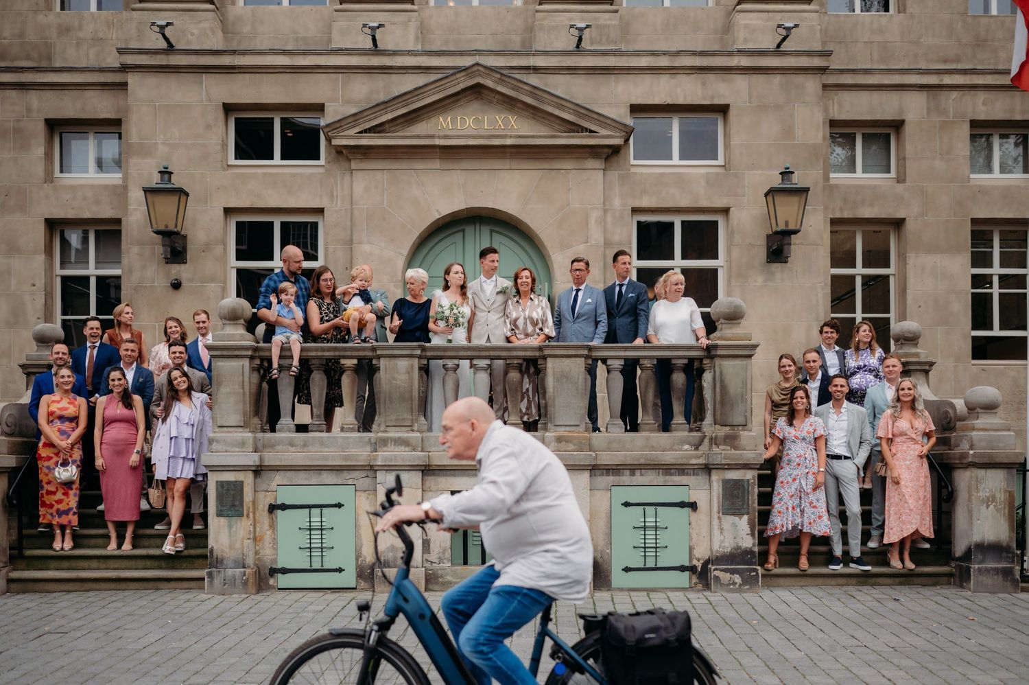 Bruiloftsviering buiten bij historisch stenen gebouw met klassieke architectuur, bruidsfotografie Brabant