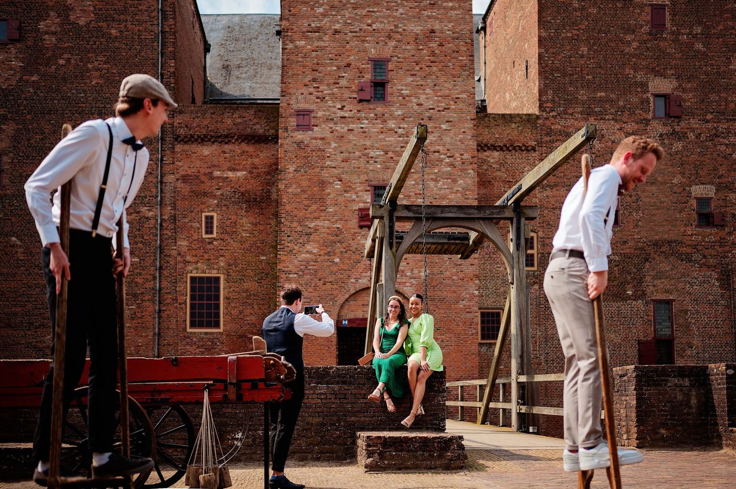 Vintage scène met mensen in bretels en kleding uit vroegere tijd die croquet spelen bij bakstenen gebouwen, lifestyle fotografie Brabant