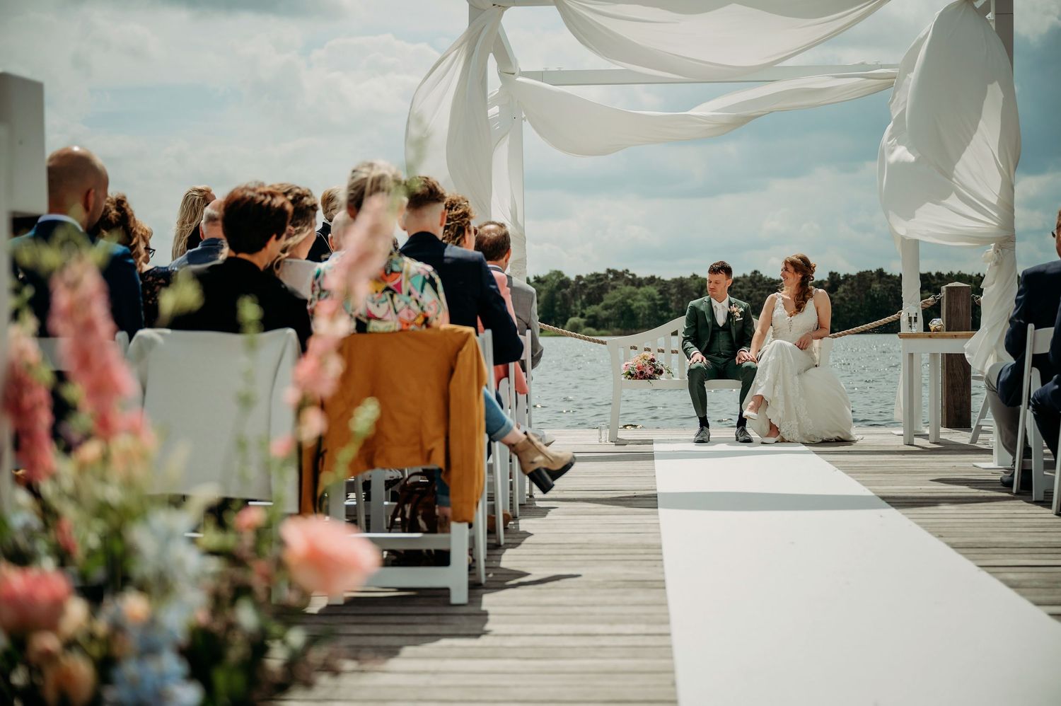 Buiten ceremonie met witte doeken en stoelen met uitzicht op water, bruidsfotografie IJM IJzereman Vught, Brabant.