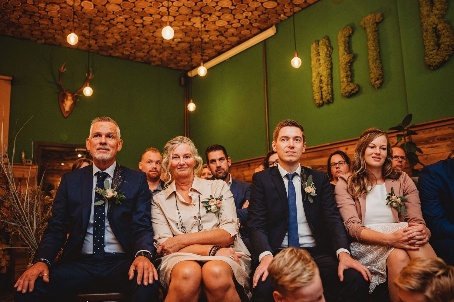 Intieme trouwreceptie in sfeervol boscafé met warm licht, spontane trouwfotografie in regio Oisterwijk