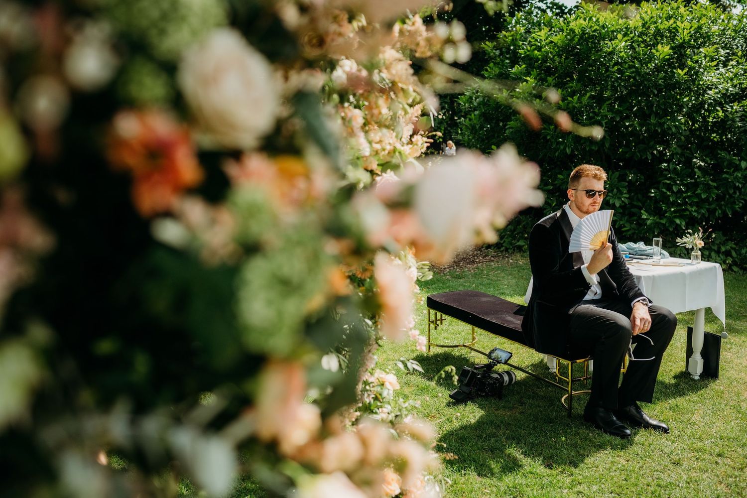 Gasten genieten van zonnige buitenceremonie in tuin, bruidsfotografie Kasteel Maurick Vught, Brabant.