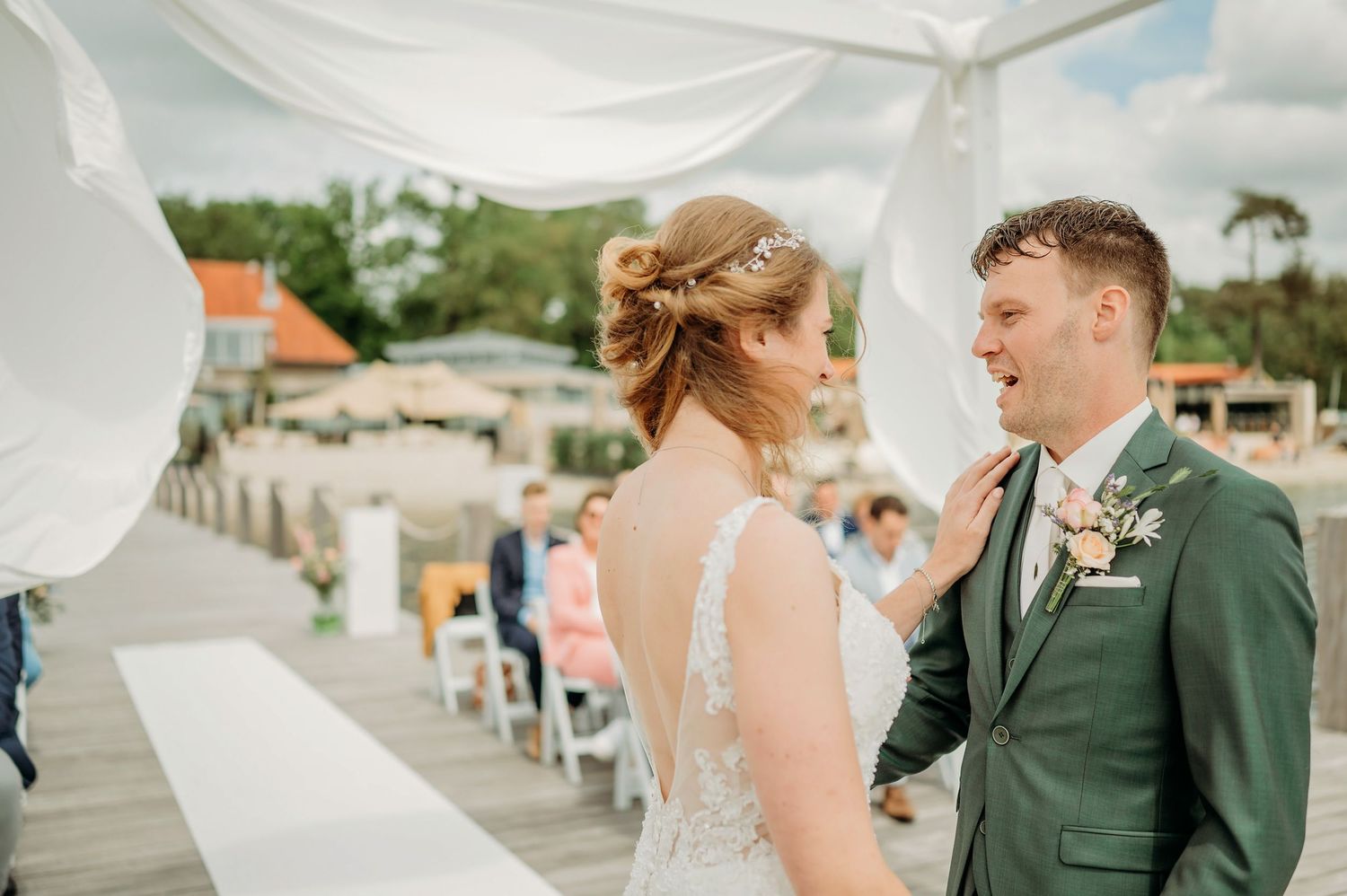 Panorama van buitenceremonie met gasten op houten dek, bruidsfotografie IJM IJzereman Vught, Brabant.