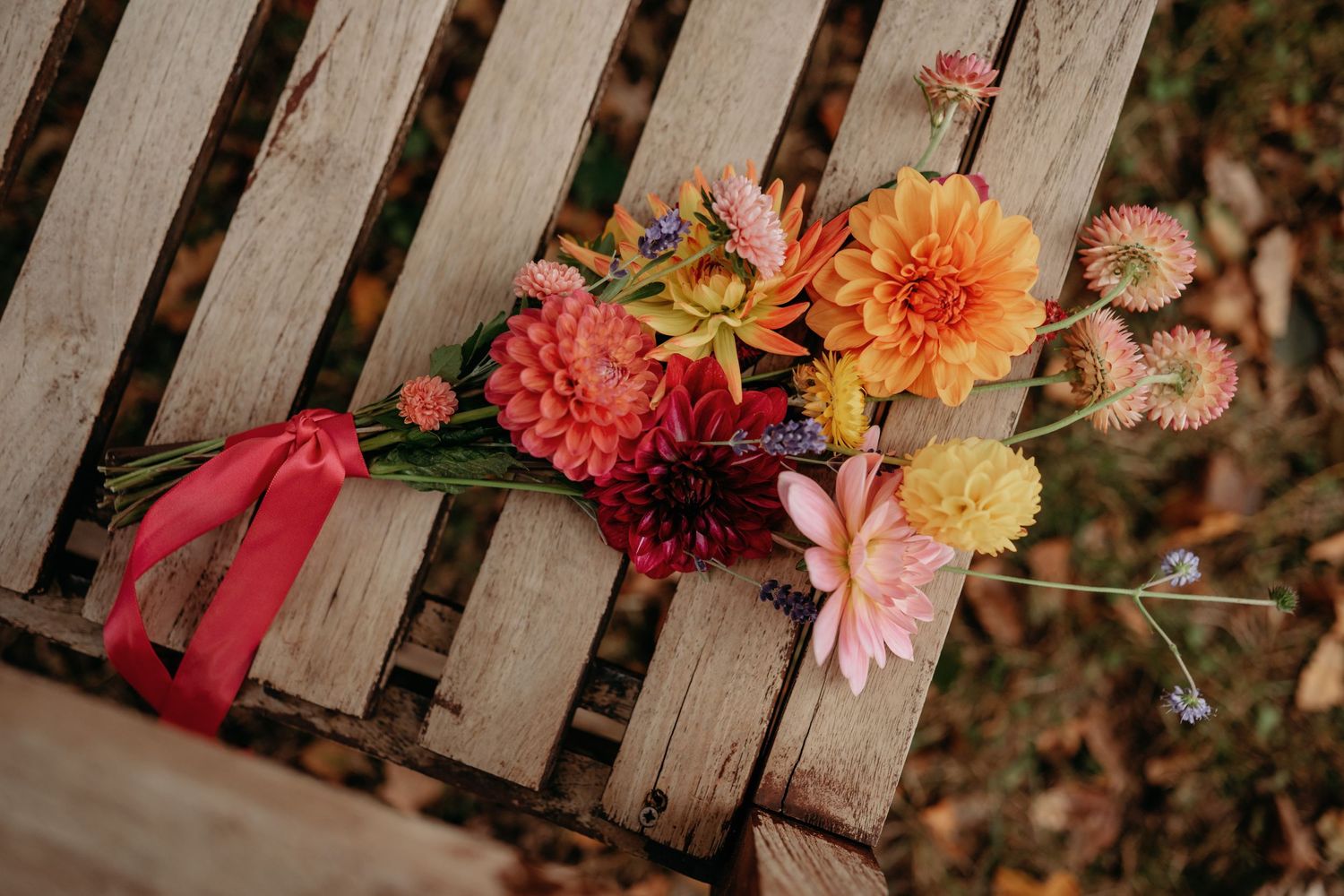 Bruidsboeket met kleurrijke bloemen op houten ondergrond, detailfoto van bruiloft in Brabant
