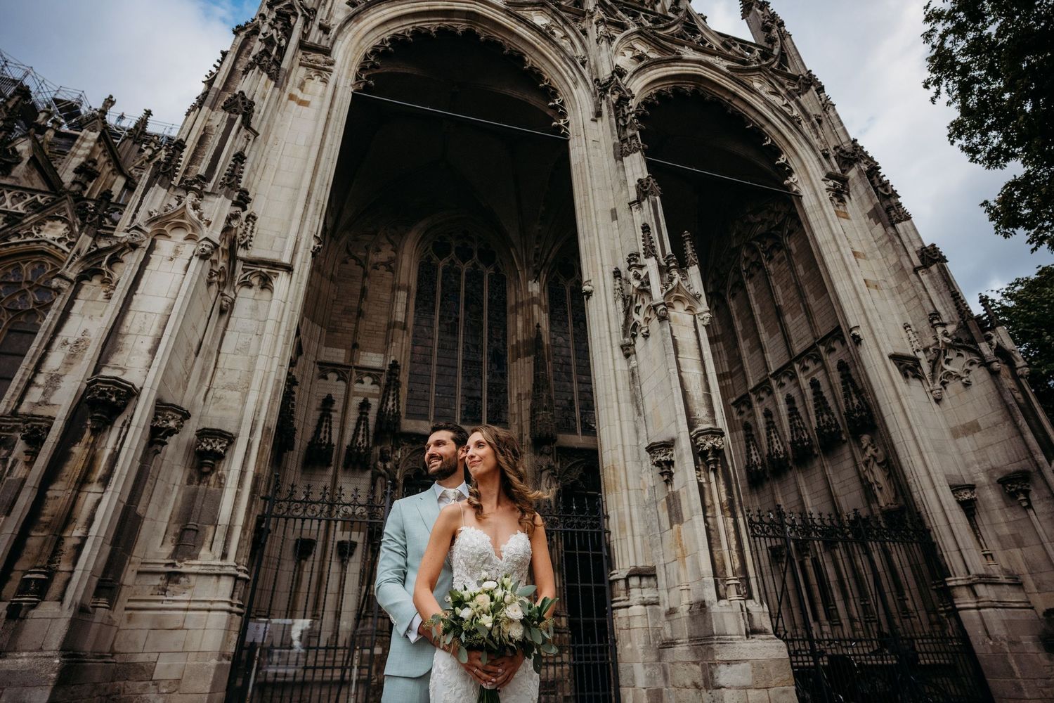 Gothic cathedral architecture forms a dramatic backdrop for a wedding photo shoot.