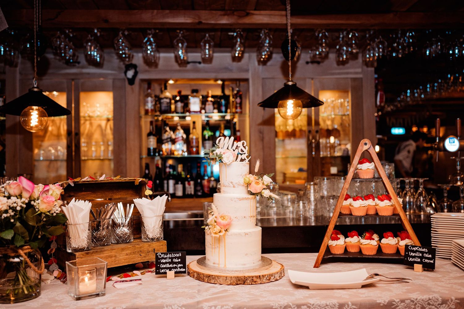 Bruidstaart en styling bij rustieke bar binnen, sfeervolle bruidsfotografie bij Mr van Eijck Oisterwijk, Brabant.