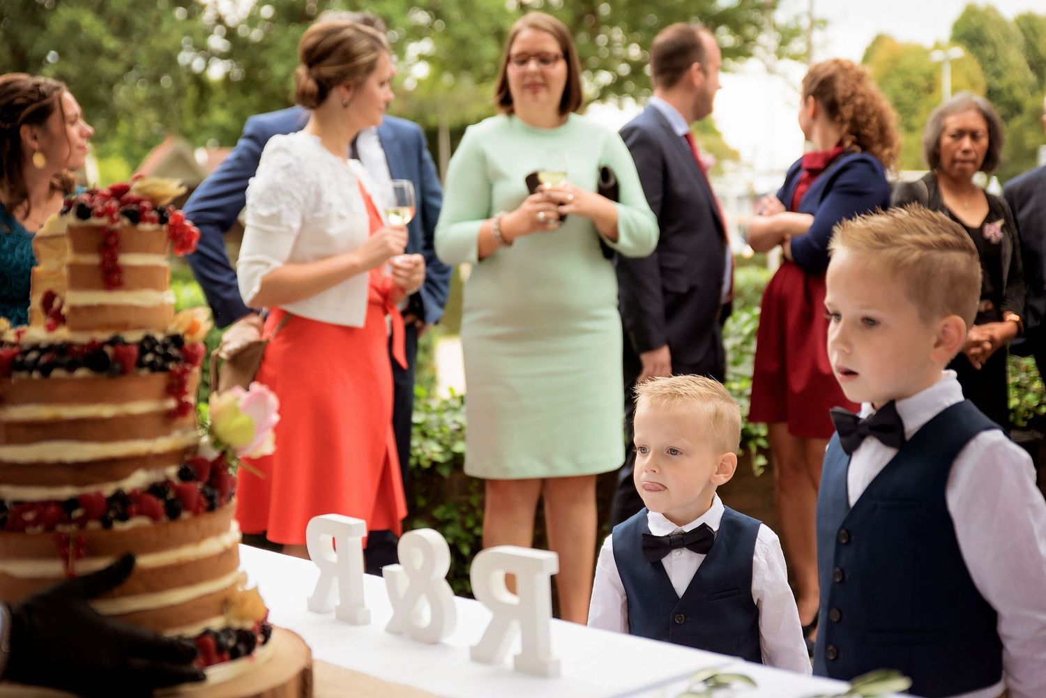 Desserttafel bij trouwreceptie met meerlaagse taart en decoratieve lekkernijen, bruiloftsfotograaf Brabant.