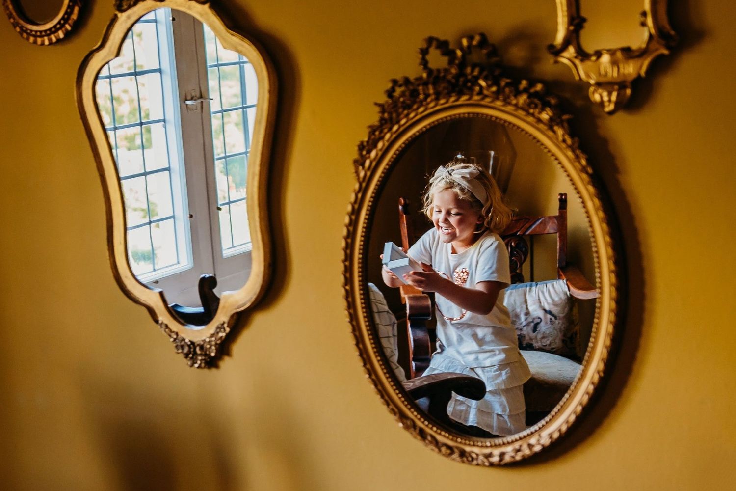 Spiegel met gouden lijst reflecteert warm licht in een elegante trouwlocatie, trouwfotografie Brabant.