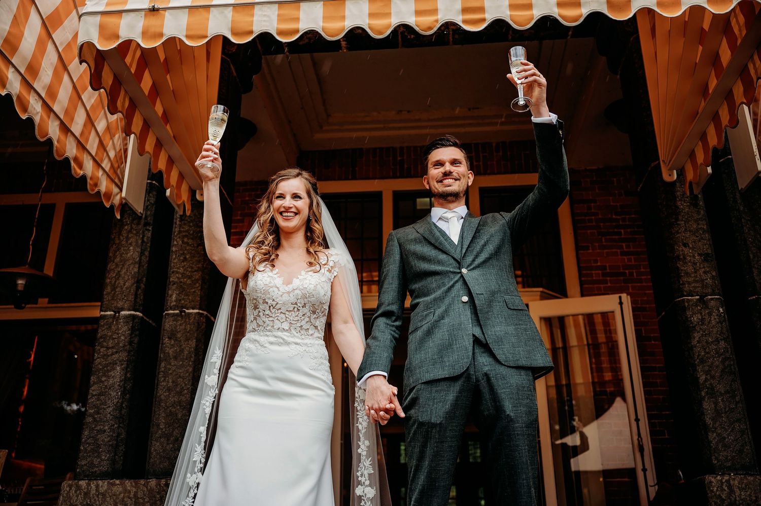Bruiloftsceremonie met rustieke houten stoelen en oranje gestreepte luifel, bruidsfotografie Brabant