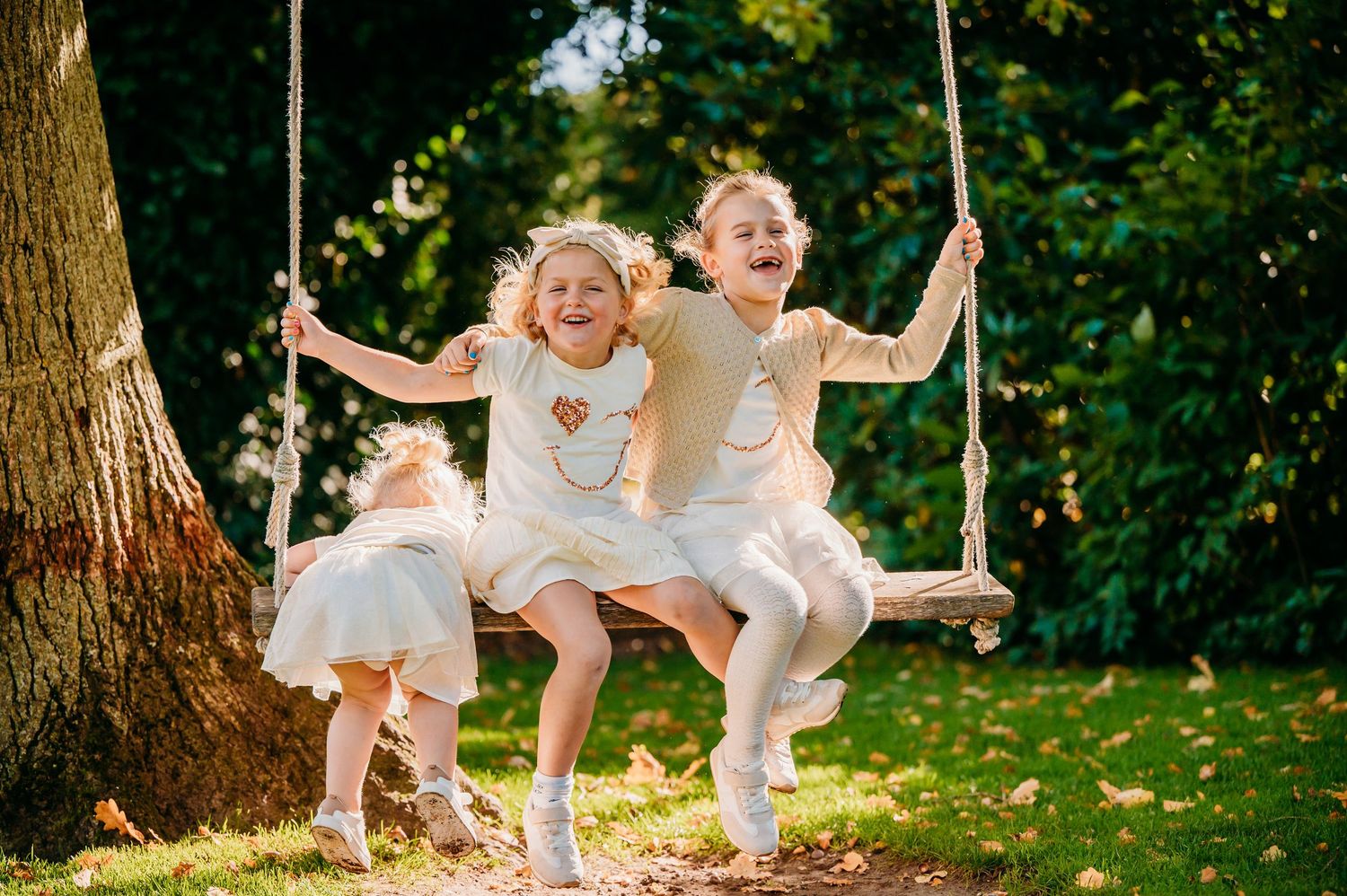 Kinderen spelen en schommelen in zonnige tuin, gezinsfotografie Kasteel Maurick Vught, Brabant.