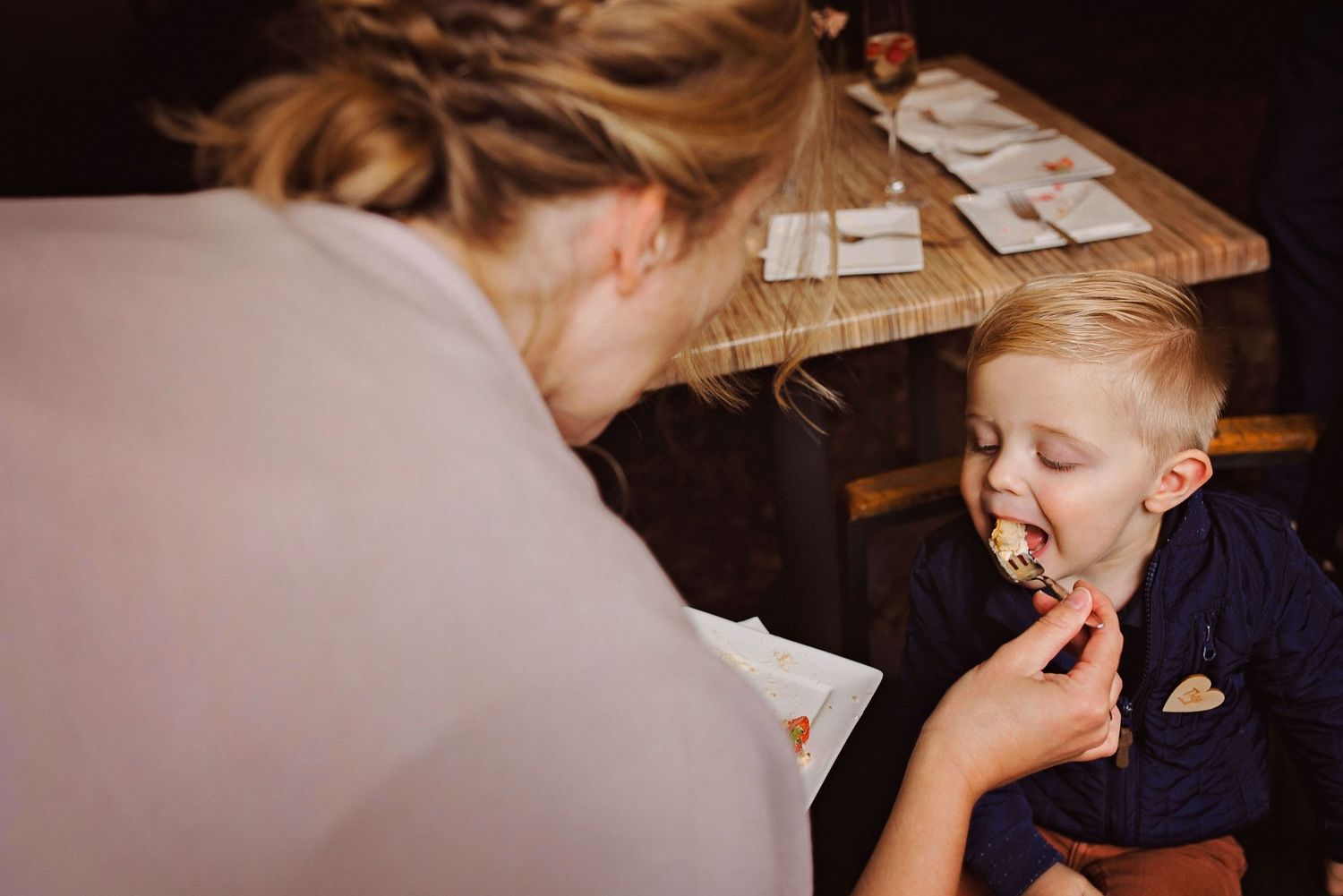 Zwart wit moment van moeder en kind tijdens bruiloft diner, pure en tijdloze reportage