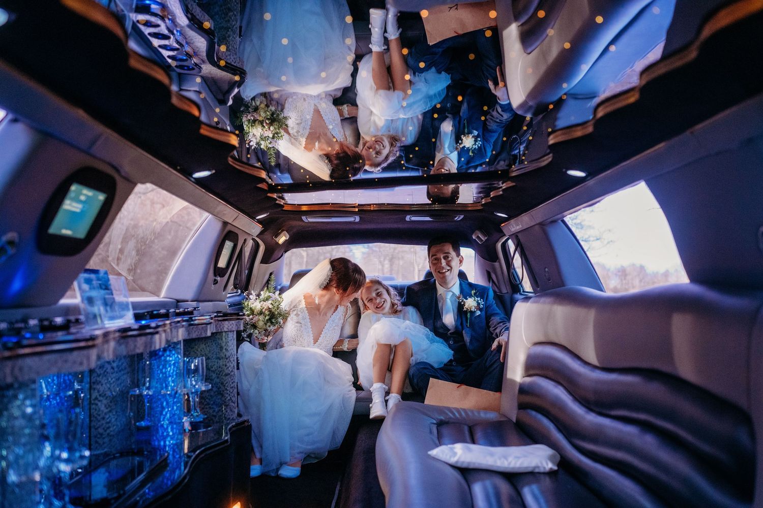 Trouwfeest in luxe limousine met blauw licht, spontane bruidsfotografie bij Boscafé Oisterwijk, Brabant.