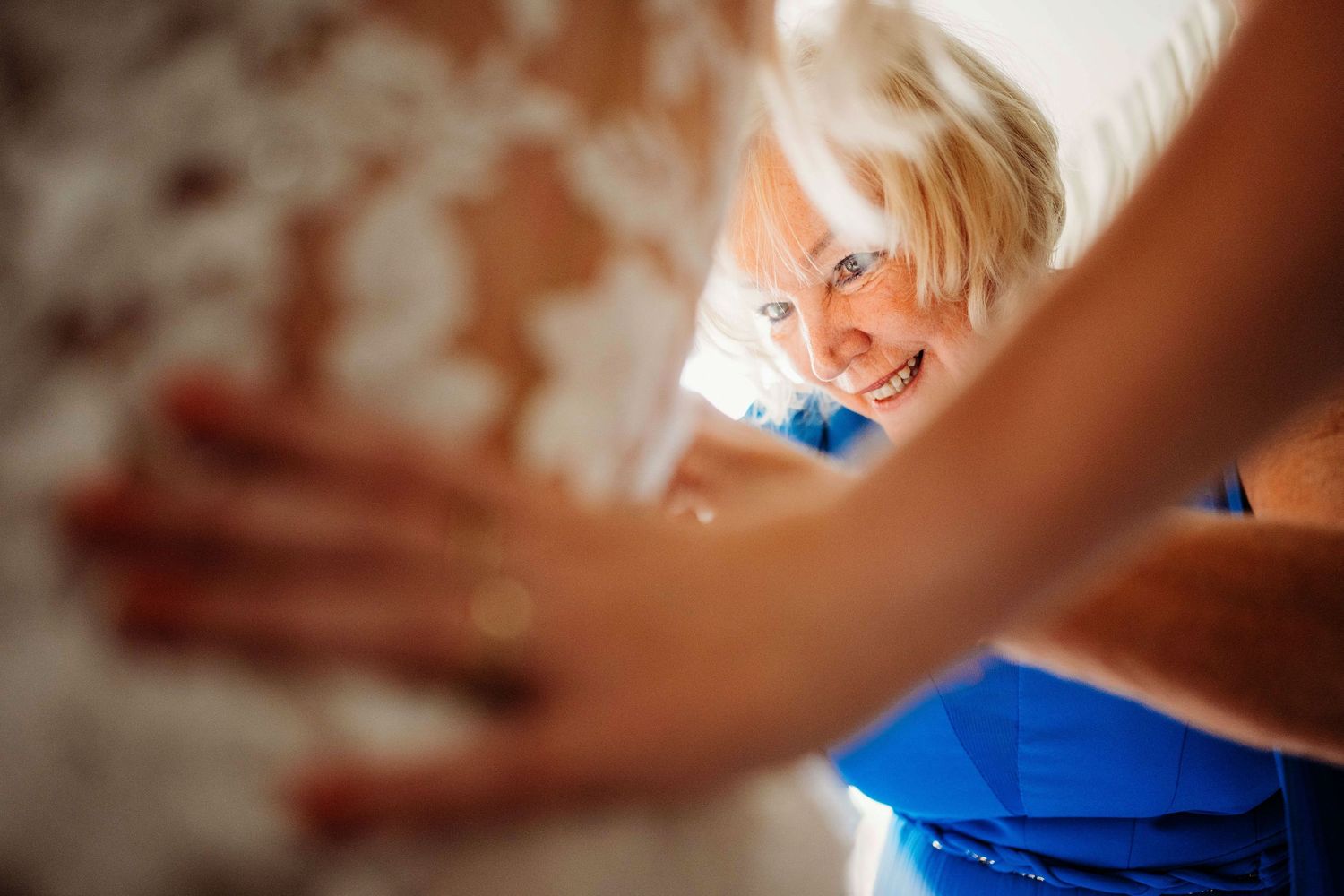 Handen vouwen trouwjurk, creatieve detail en reportagefotografie in Den Bosch en omgeving Brabant.