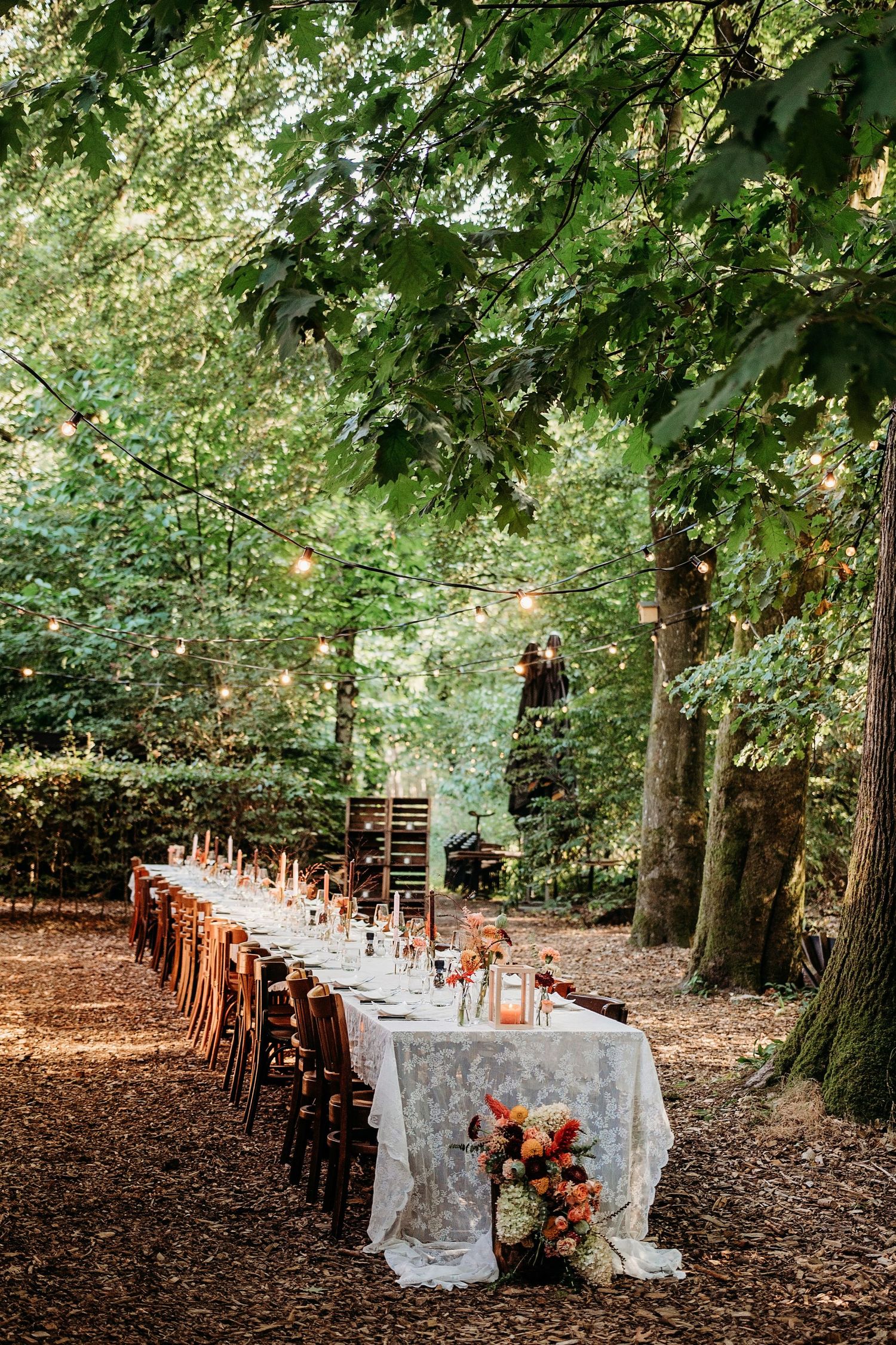 Bruiloft diner aan lange tafels in bosrijke omgeving in Brabant, sfeervolle en natuurlijke trouwfotografie
